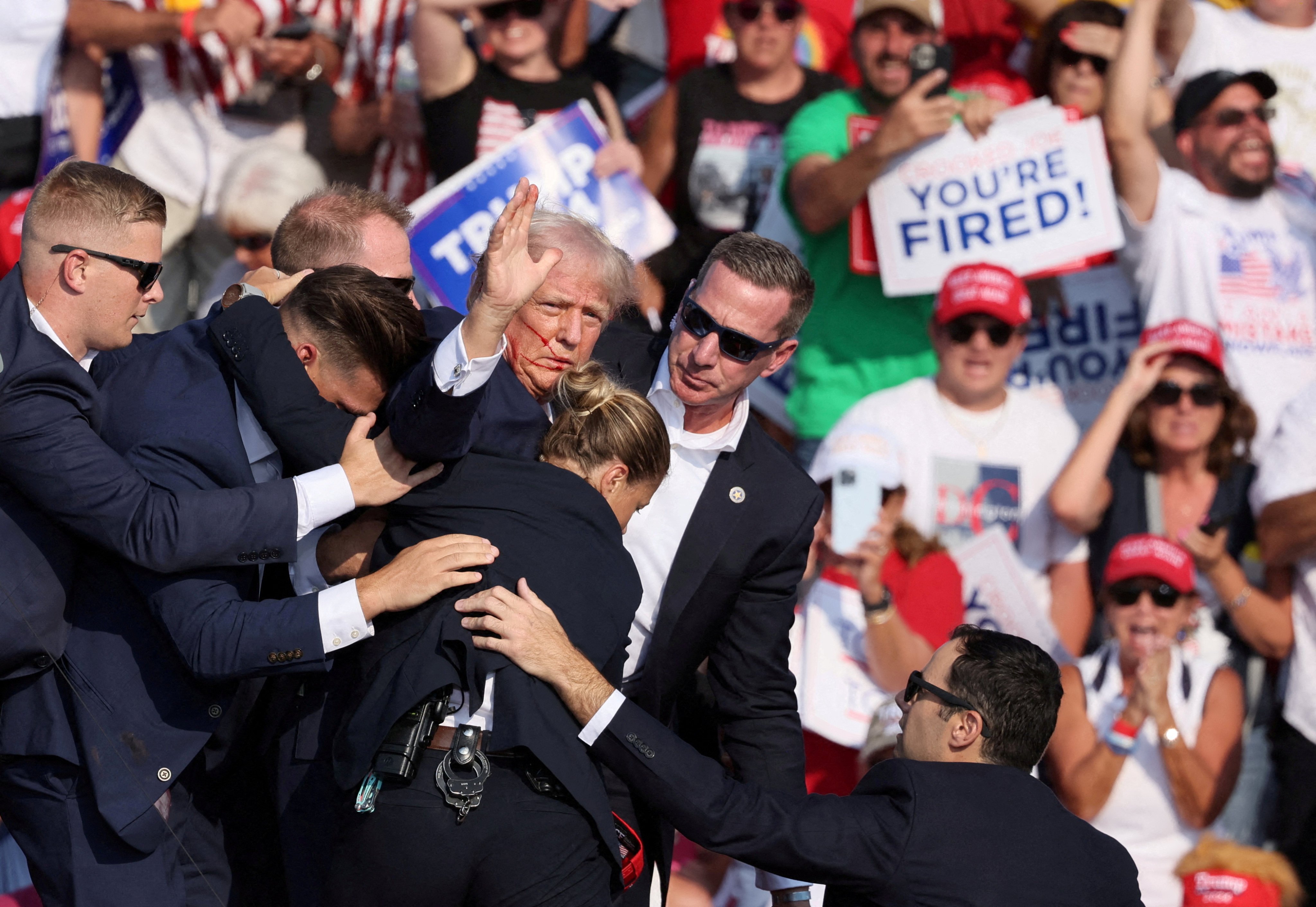 Donald Trump is escorted offstage by security officers after he was shot in the ear during a campaign rally in Butler, Pennsylvania, on Saturday. Photo: Reuters