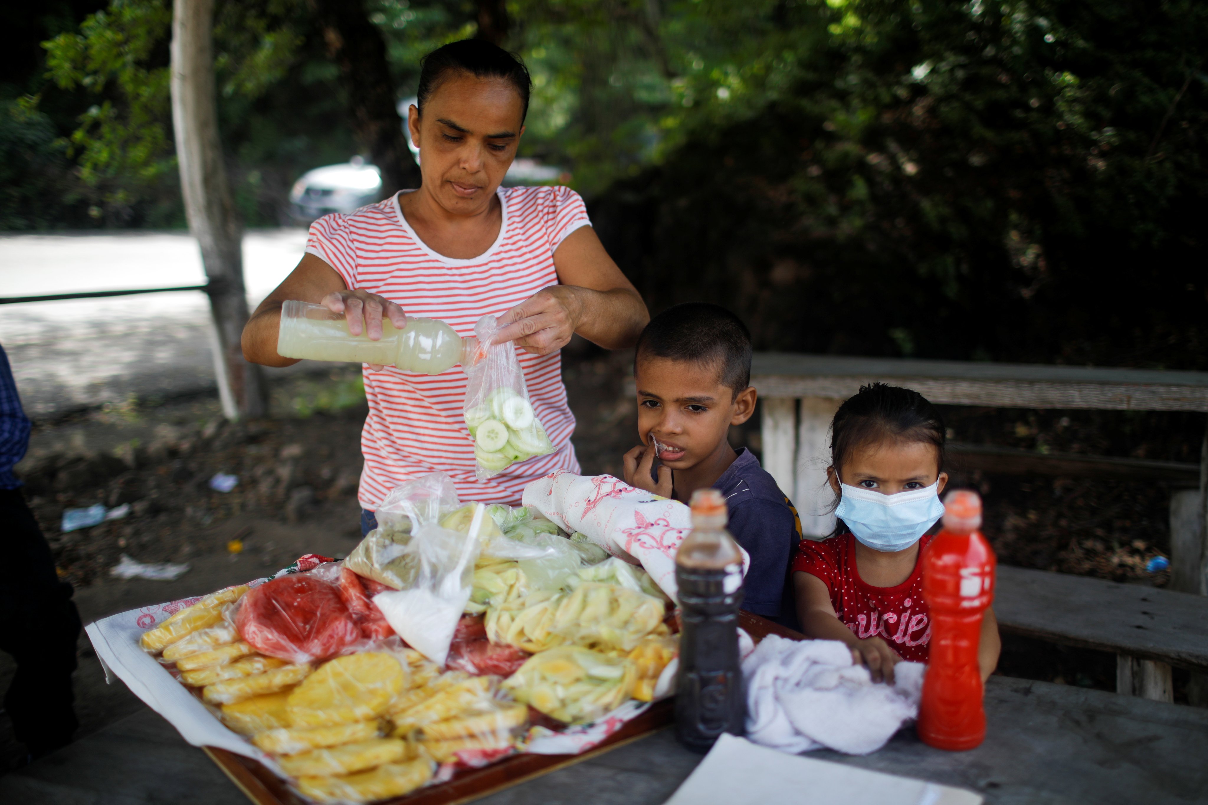 A fruit seller and her children on El Zonte Beach El Salvador, where more than 1,000 minors have been convicted of crimes under a state of emergency in force since March 2022. Photo: Reuters