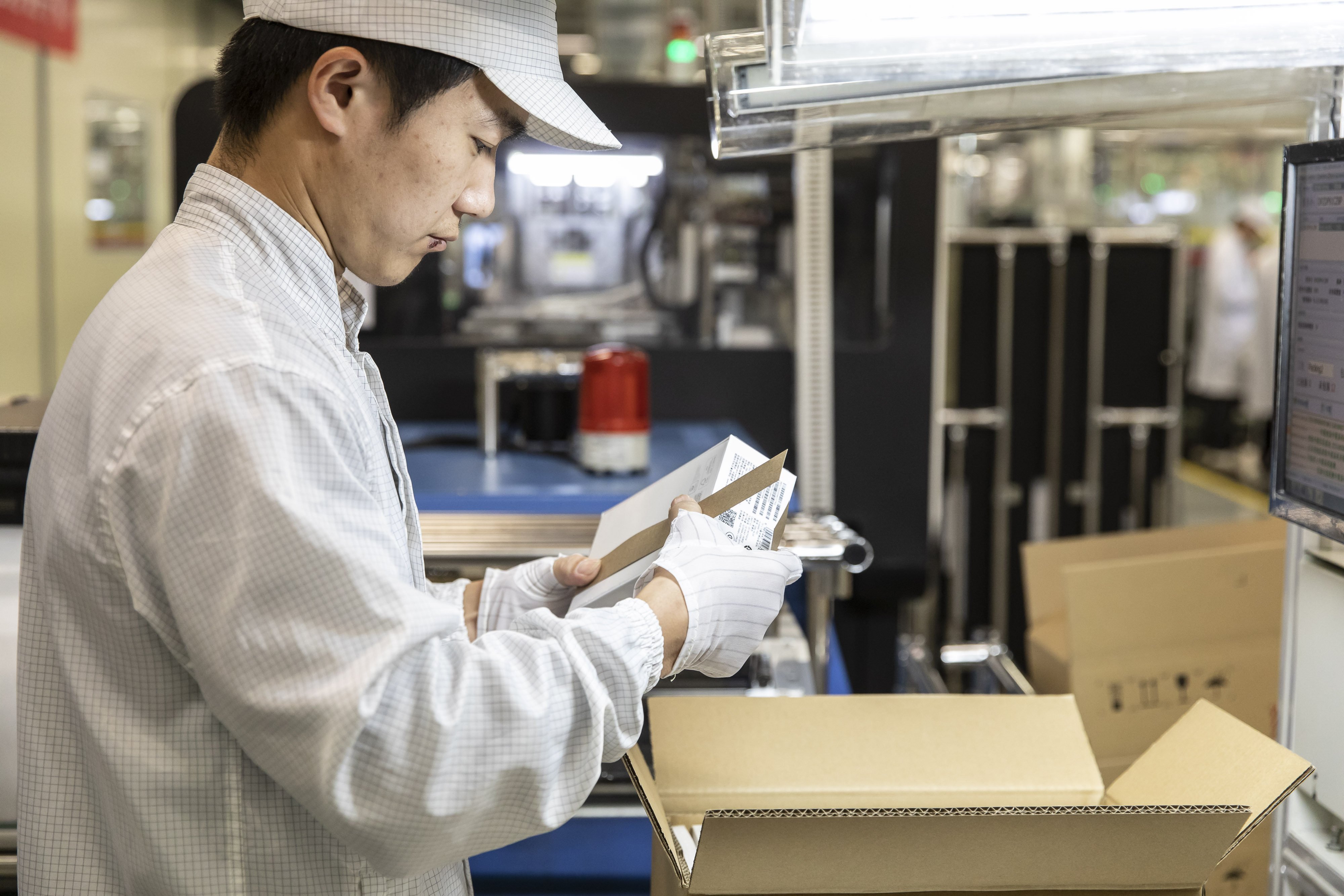 An employee handles a box on the assembly line of a Huawei Technologies in Dongguan, China. India is expected to speed up the process of issuing visas for Chinese technicians. Photo: Bloomberg