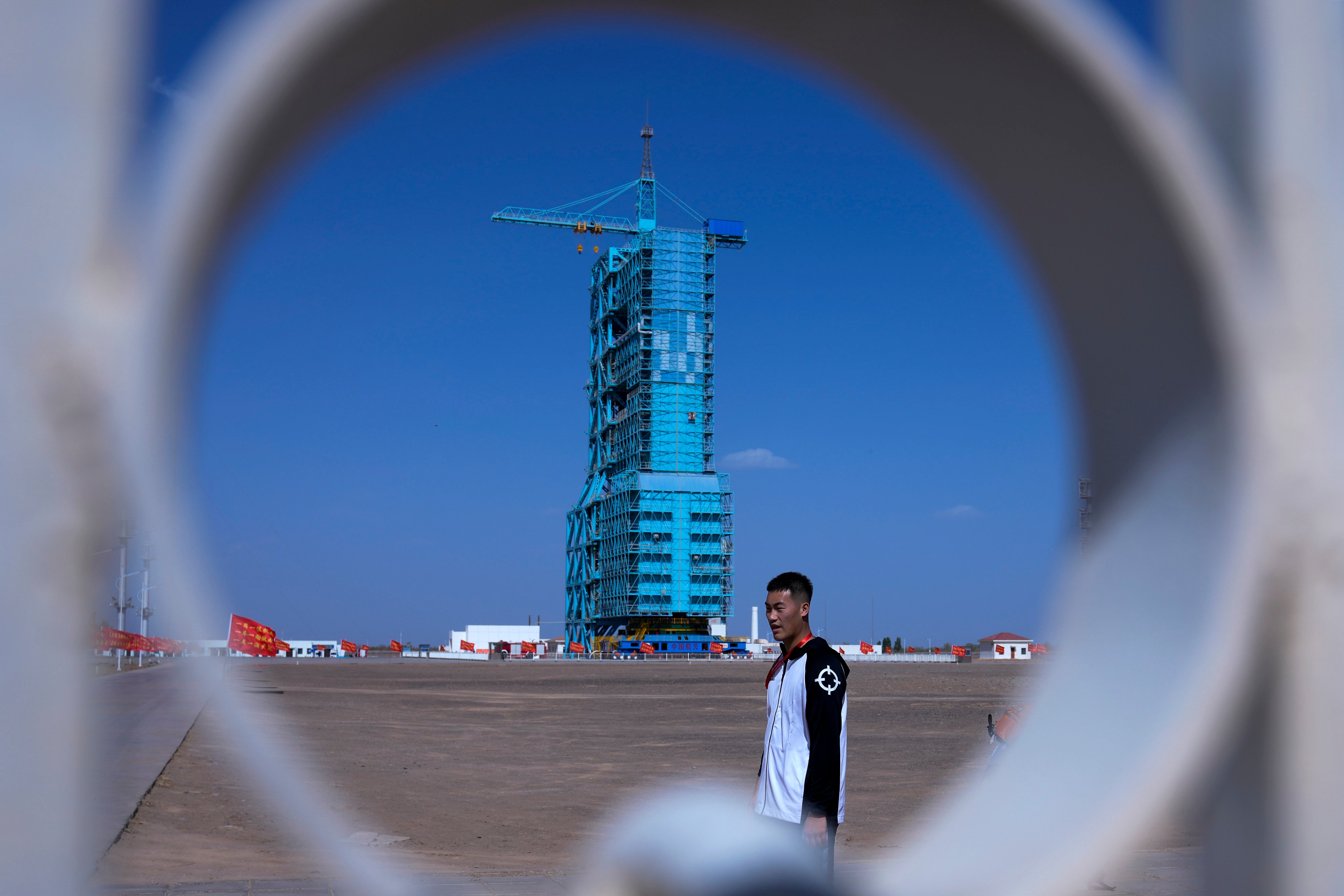 A Chinese soldier walks by the Shenzhou-18 spacecraft sitting atop a Long March rocket covered on a launch pad at the Jiuquan Satellite Launch Centre in northwest China on April 24, 2024. Photo: AP