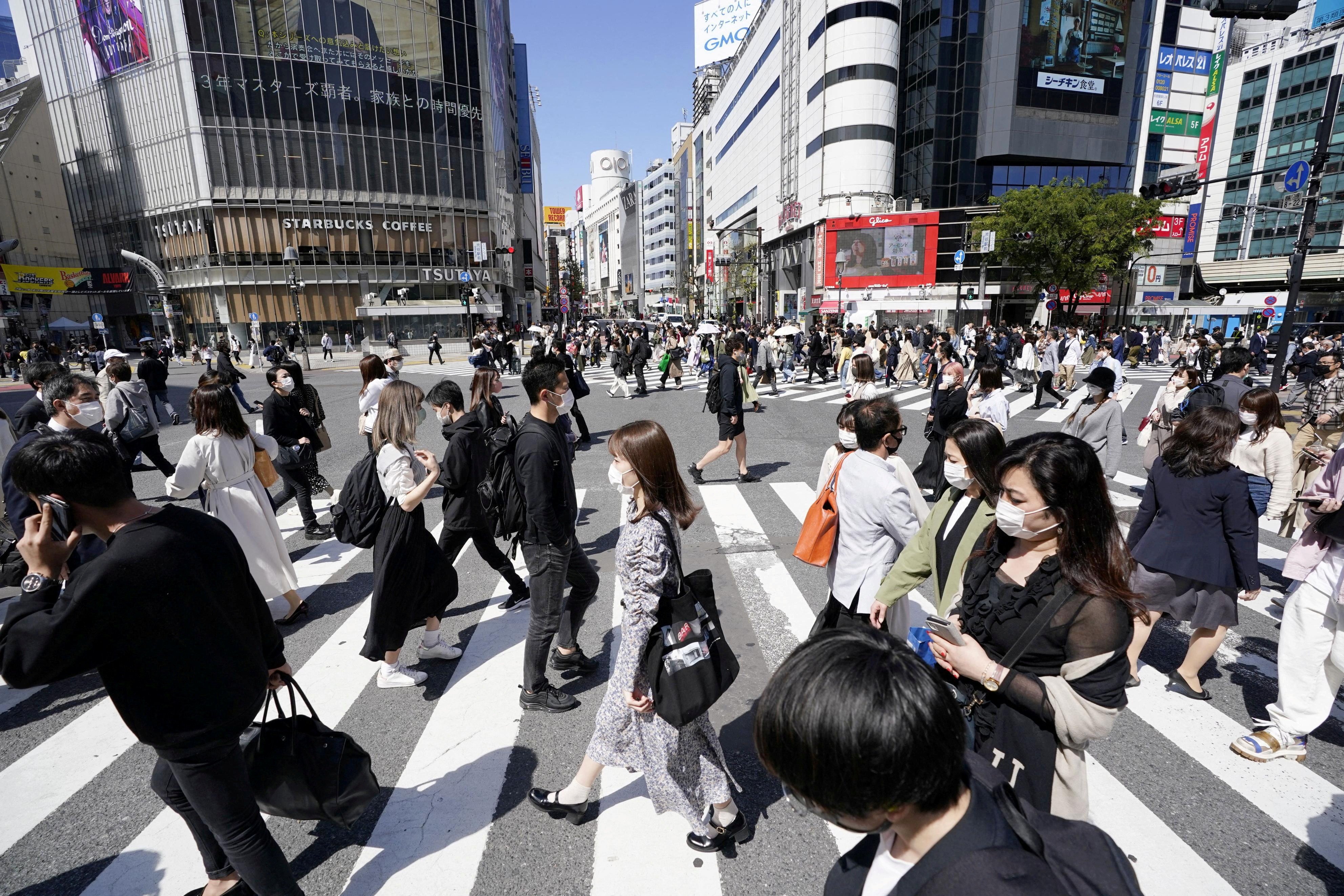 People wear protective face masks in Tokyo. Japan is experiencing its 11th wave of infections. Photo: Kyodo via Reuters