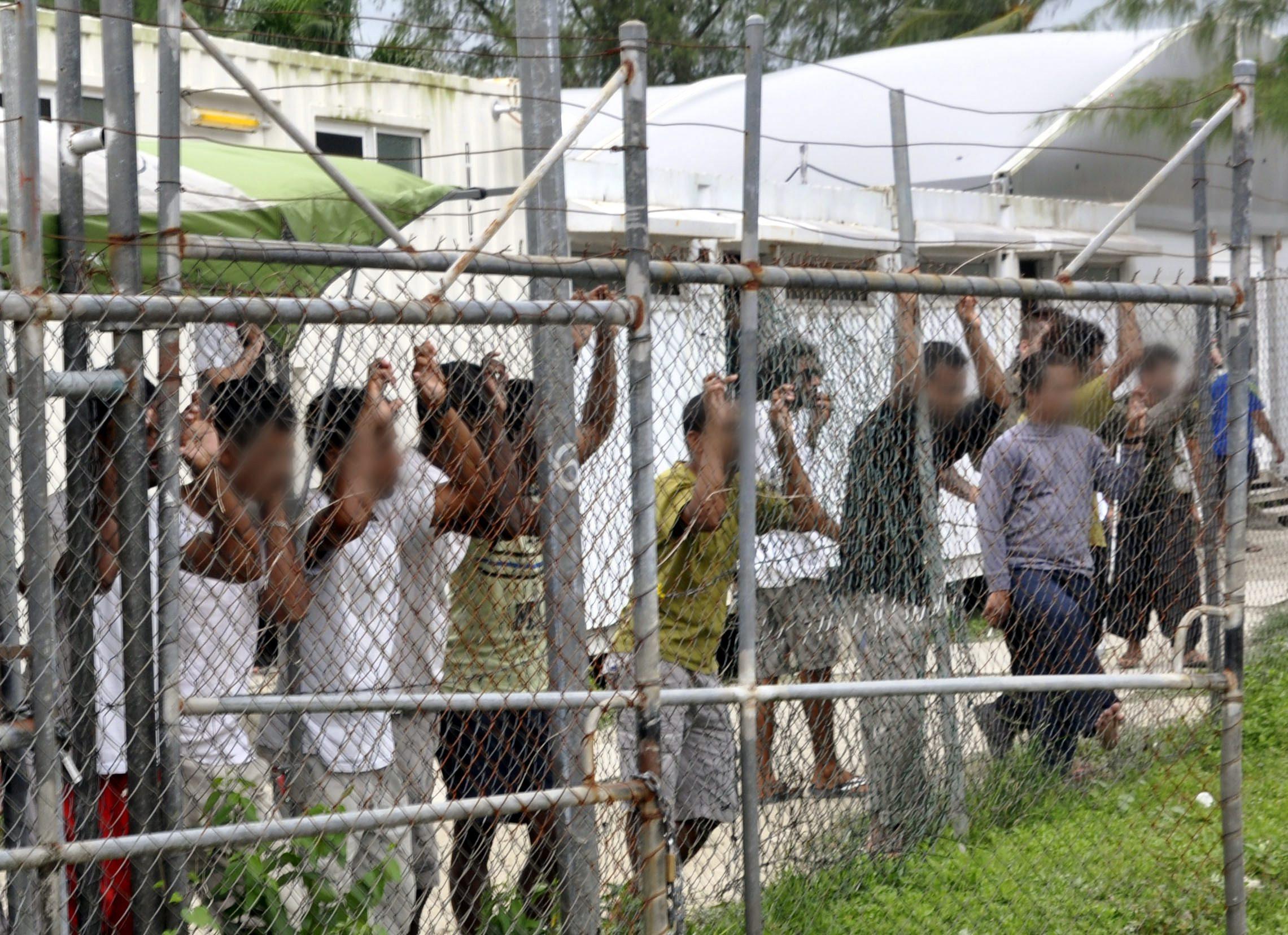 A file picture dated March 2014 shows asylum seekers behind a fence at the Manus Island detention centre in Papua New Guinea. Australia and PNG agreed to close the detention centre following a decision by the PNG Supreme Court declaring it unconstitutional, but many refugees still remain there. Photo: EPA