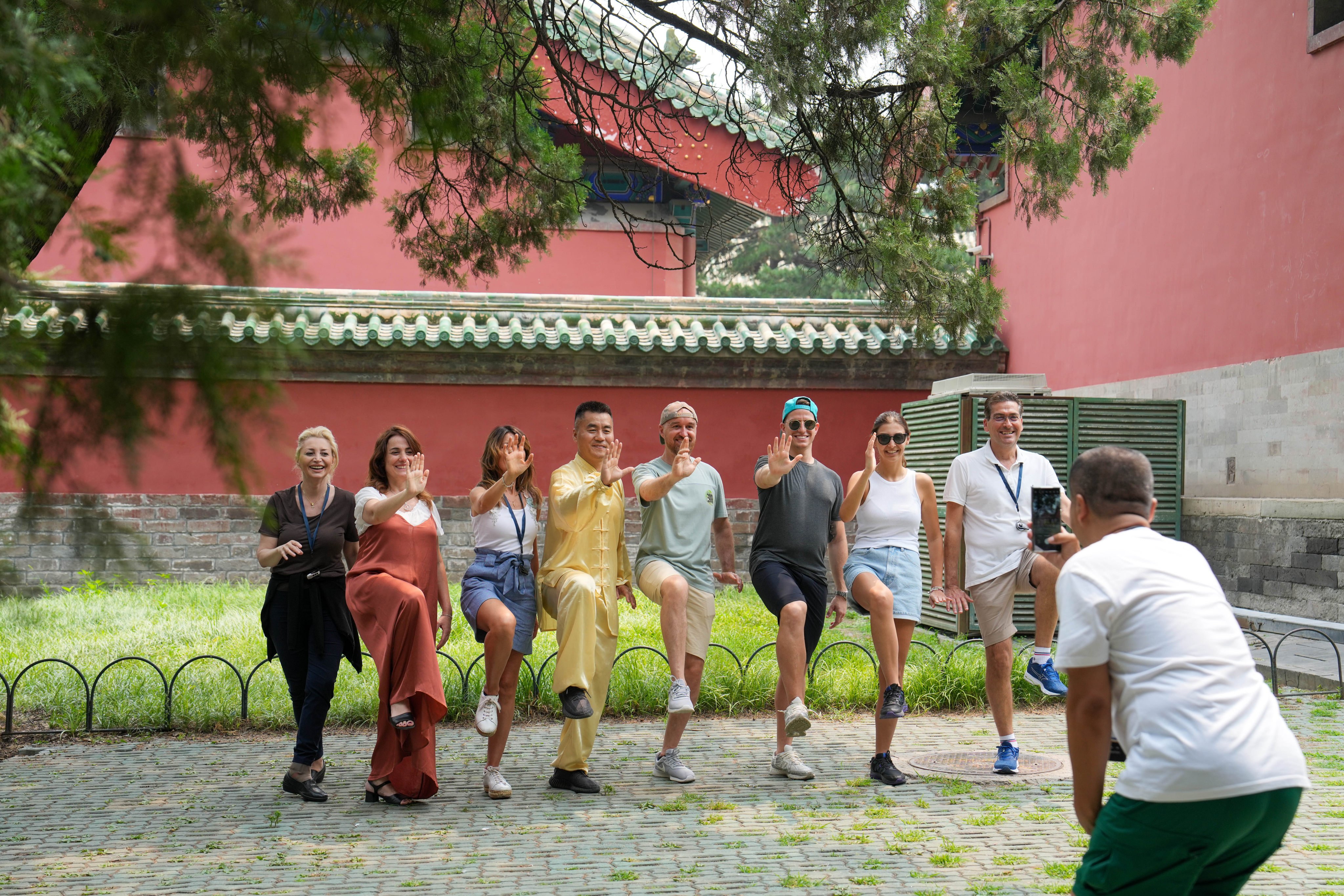 Tourists from Italy pose for a photo after practicing tai chi at the Tiantan (Temple of Heaven) Park in Beijing, on July 9. Photo: Xinhua
  