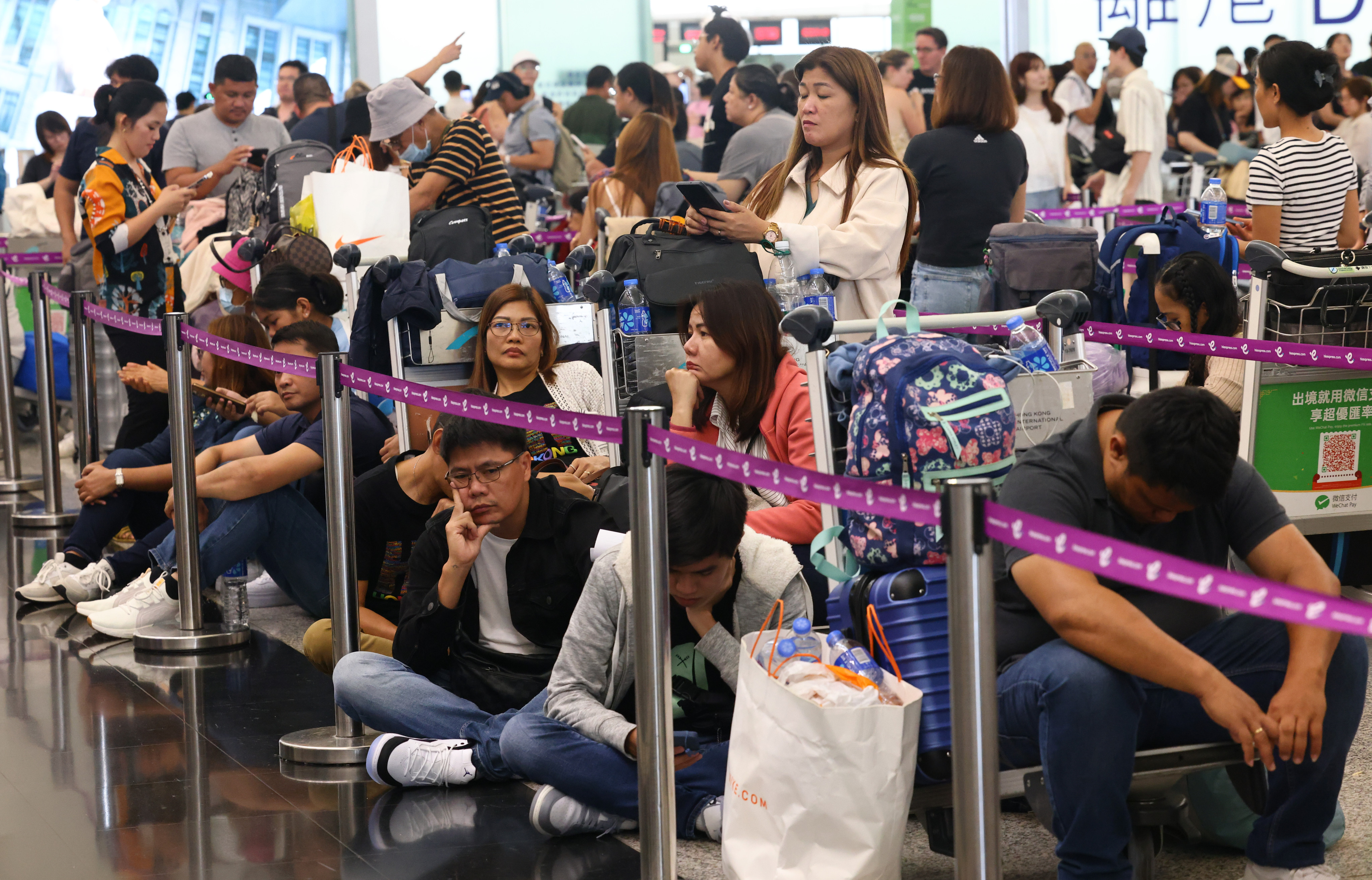 Passengers wait to be checked in at the airport. Photo: Dickson Lee