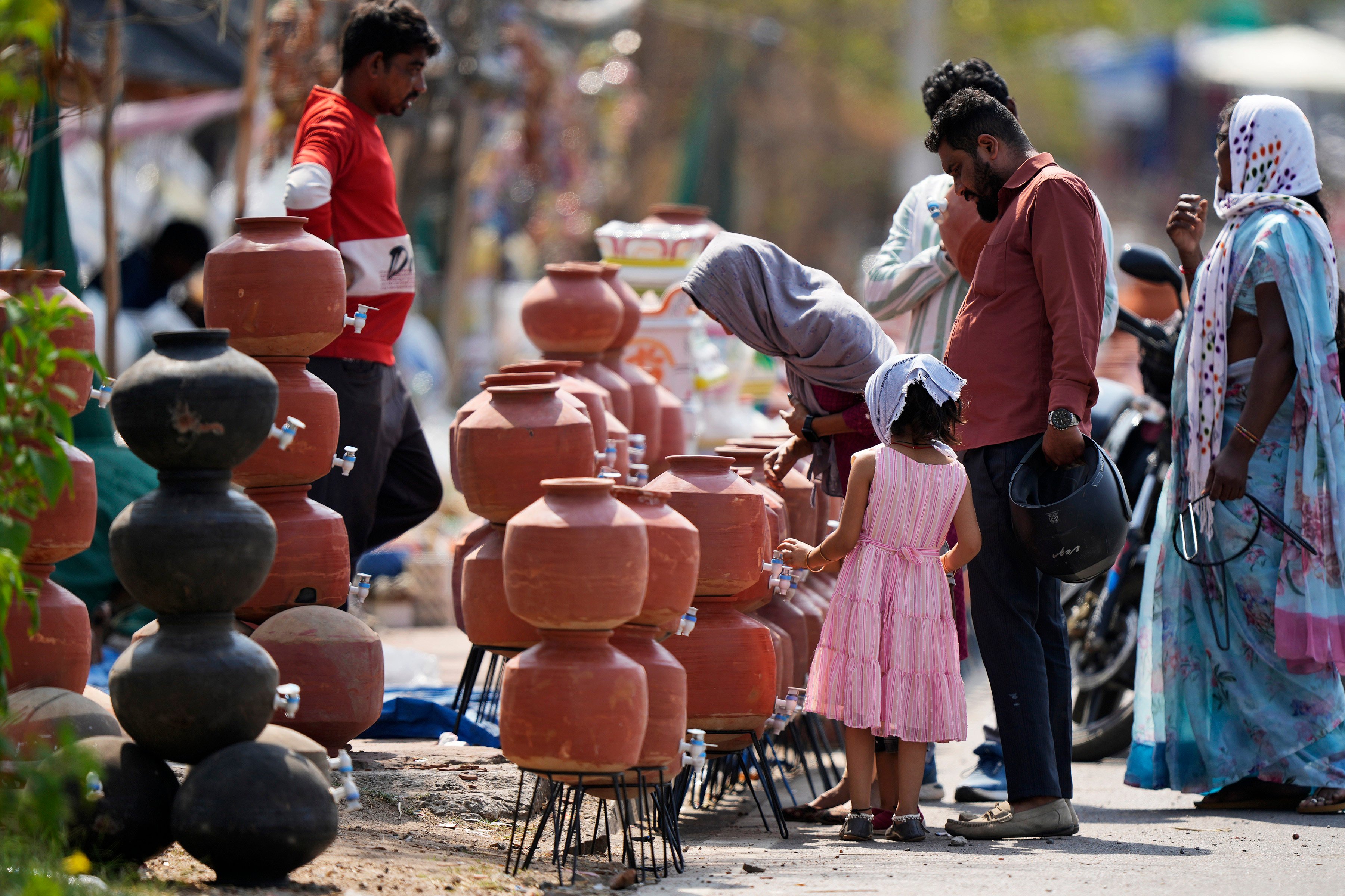 People shop for earthen water vessels, known locally as poor man’s refrigerator, from a roadside vendor in Hyderabad, India, in May. Photo: AP