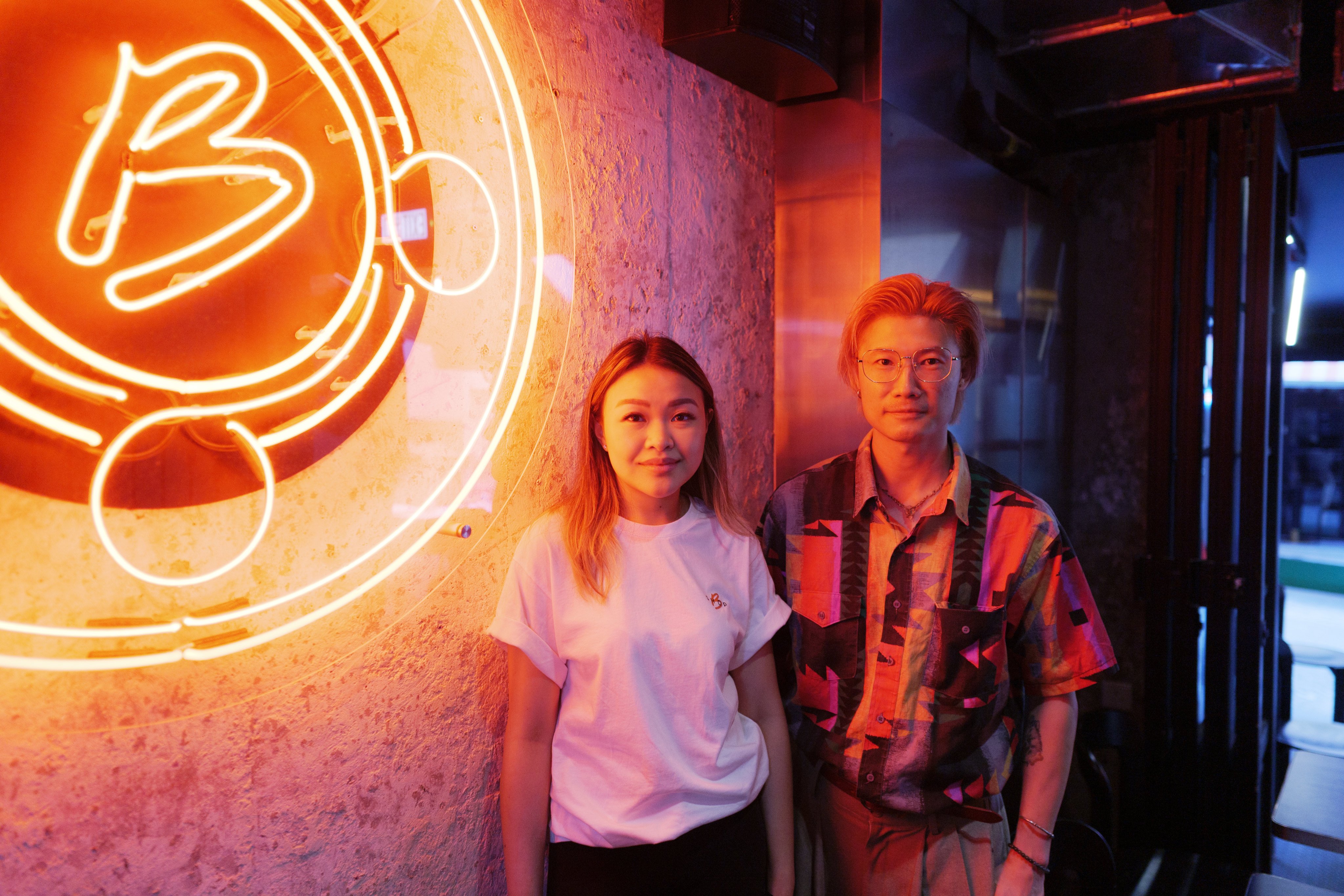 Shop B founder Natalie Ngag and artist Jive Lau stand beside her restaurant’s neon sign. Photo: Daniel Suen