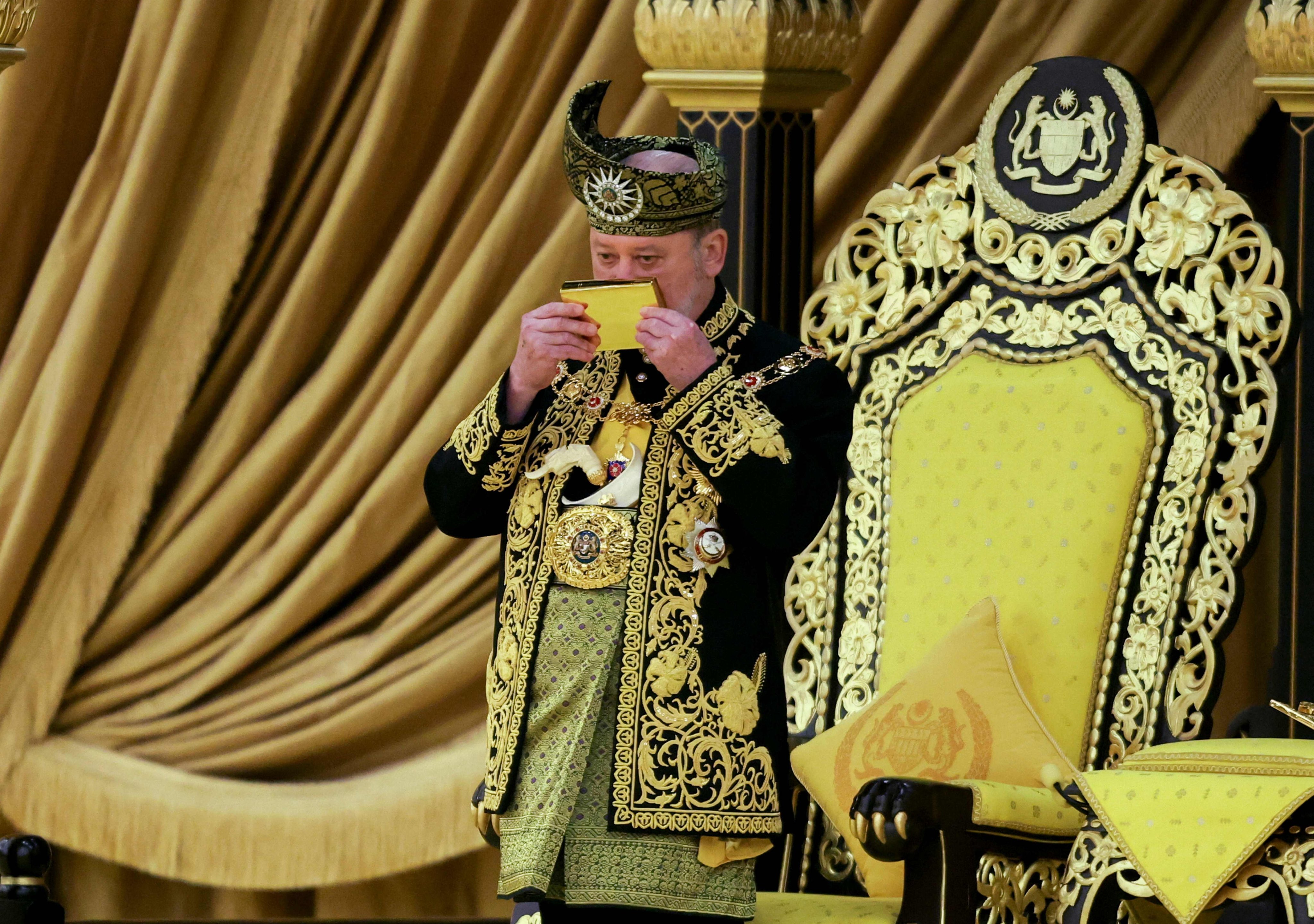 The 17th King of Malaysia, Sultan Ibrahim Sultan Iskandar, kisses a copy of the Koran during his coronation at the National Palace in Kuala Lumpur on July 20. Photo: AFP