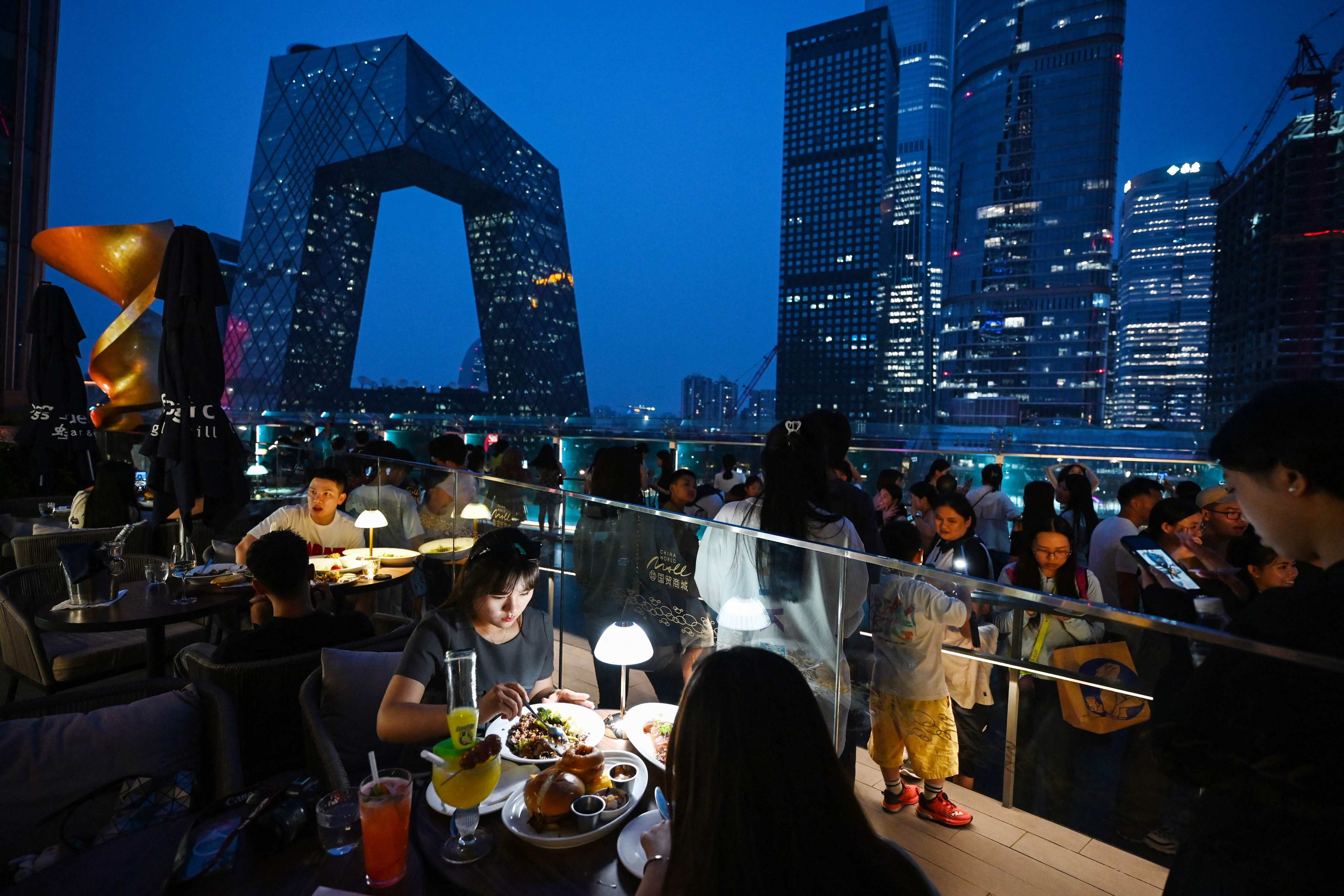 People eat in a restaurant in Beijing’s central business district on July 11. Chinese leaders recognise that stabilising the economy is crucial to attracting foreign companies. Photo: AFP