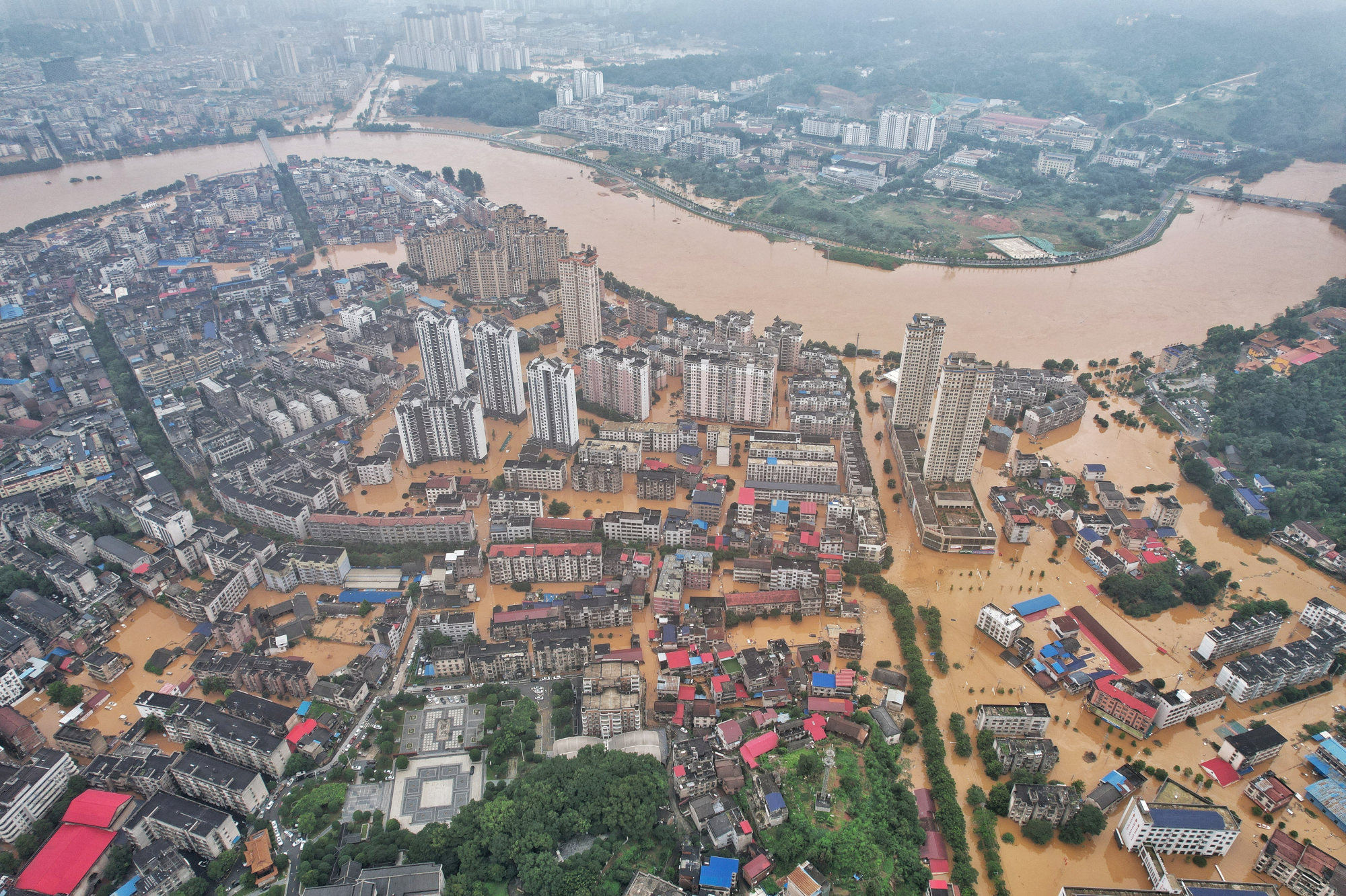 FILE PHOTO: A drone view shows flooded areas along an overflowing river following heavy rainfall in Pingjiang county of Yueyang, Hunan province, China July 2, 2024. Extreme weather triggered is setting off alarm bells in China’s insurance sector, the world’s second largest, as it needs to mitigate risks from the economic damage wreaked by the growing incidents of droughts, floods and landslides across the country. Photo: Reuters