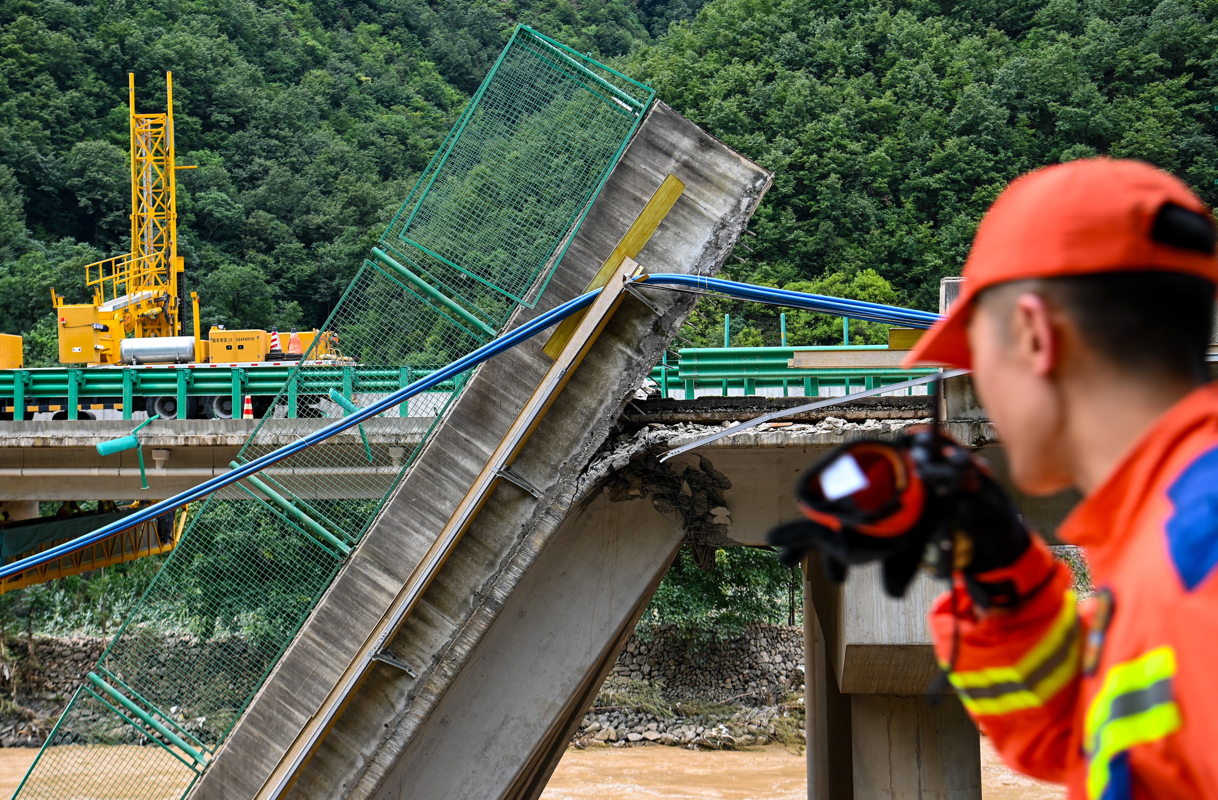 Rescuers work at the site of a bridge collapse in Zhashui county in Shangluo on Saturday after torrential rain in Shaanxi province. Some 15 people died in the disaster. Photo: Xinhua