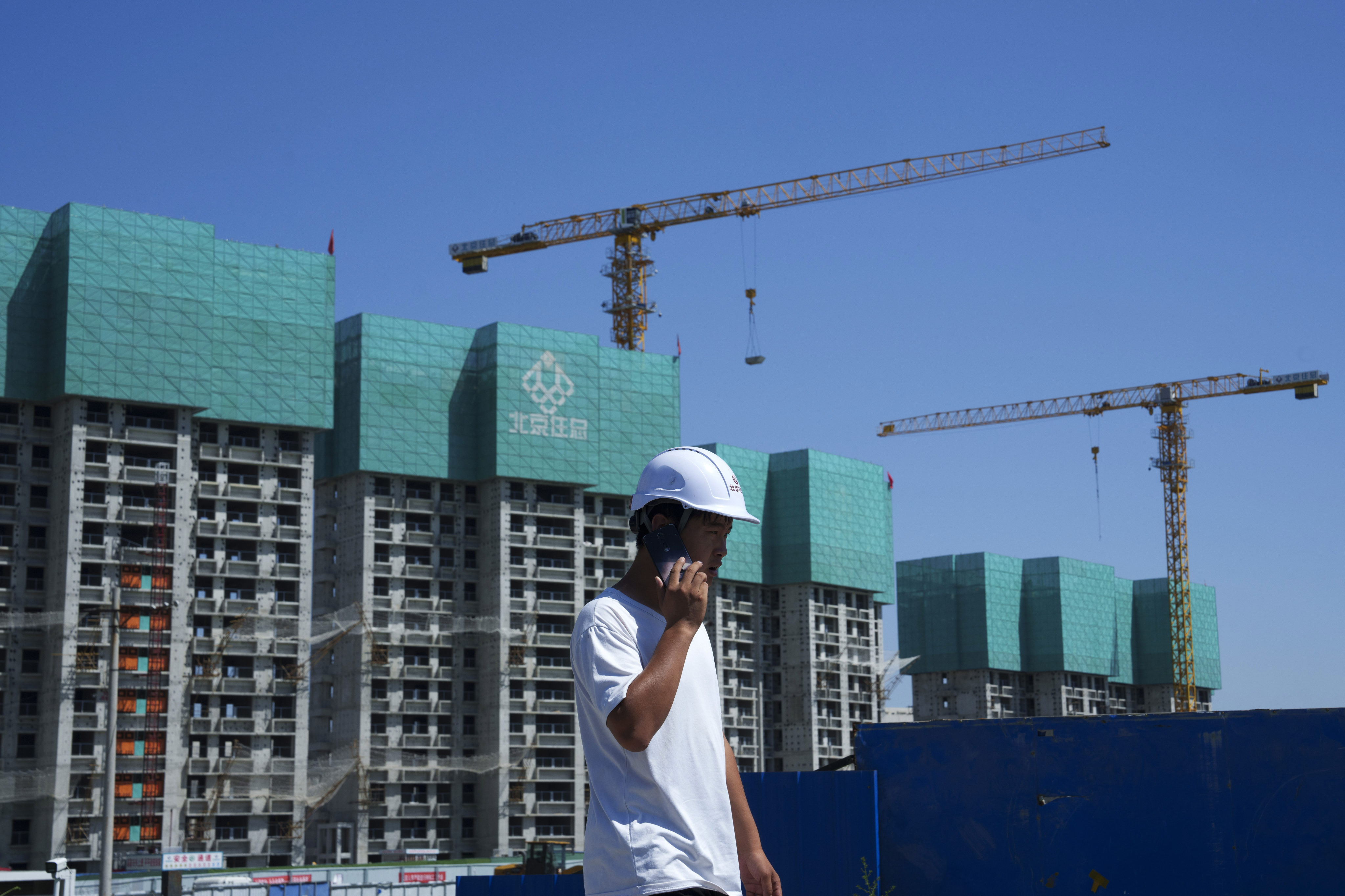 A construction worker walks past a housing project under construction on the outskirts of Beijing. Photo: AP
