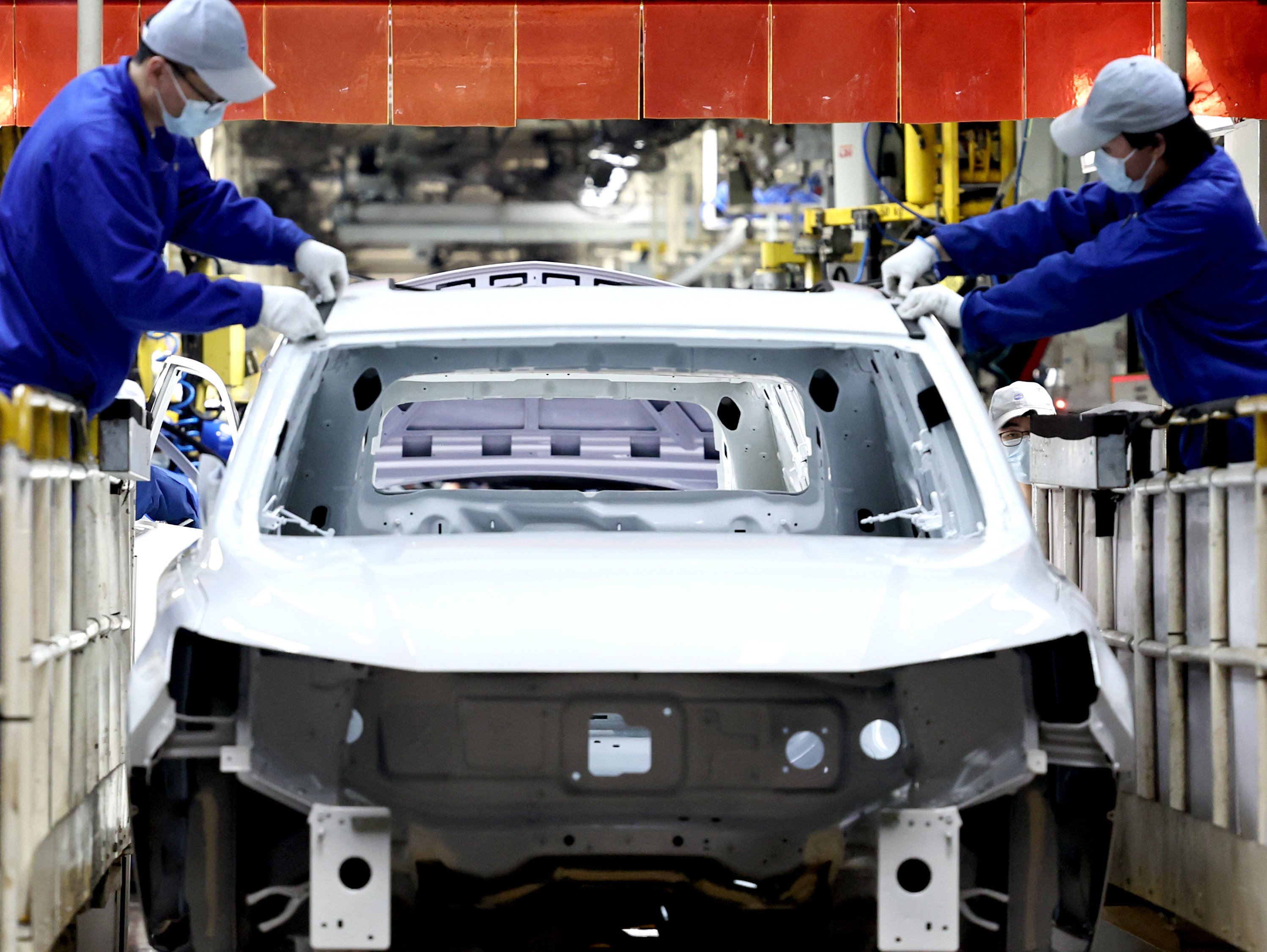 Chinese factory workers assemble a car at an SAIC Motor plant in Shanghai. Photo: Xinhua