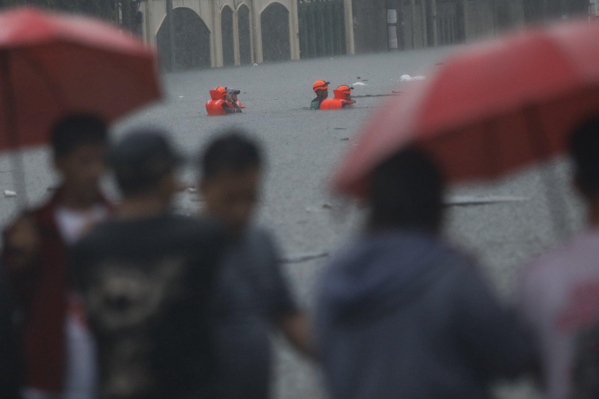 Rescuers walk through chest-deep flood waters in Quezon City, Metro Manila, on Wednesday amid monsoon rains supercharged by Typhoon Gaemi off the Philippines’ coast. Photo: EPA-EFE