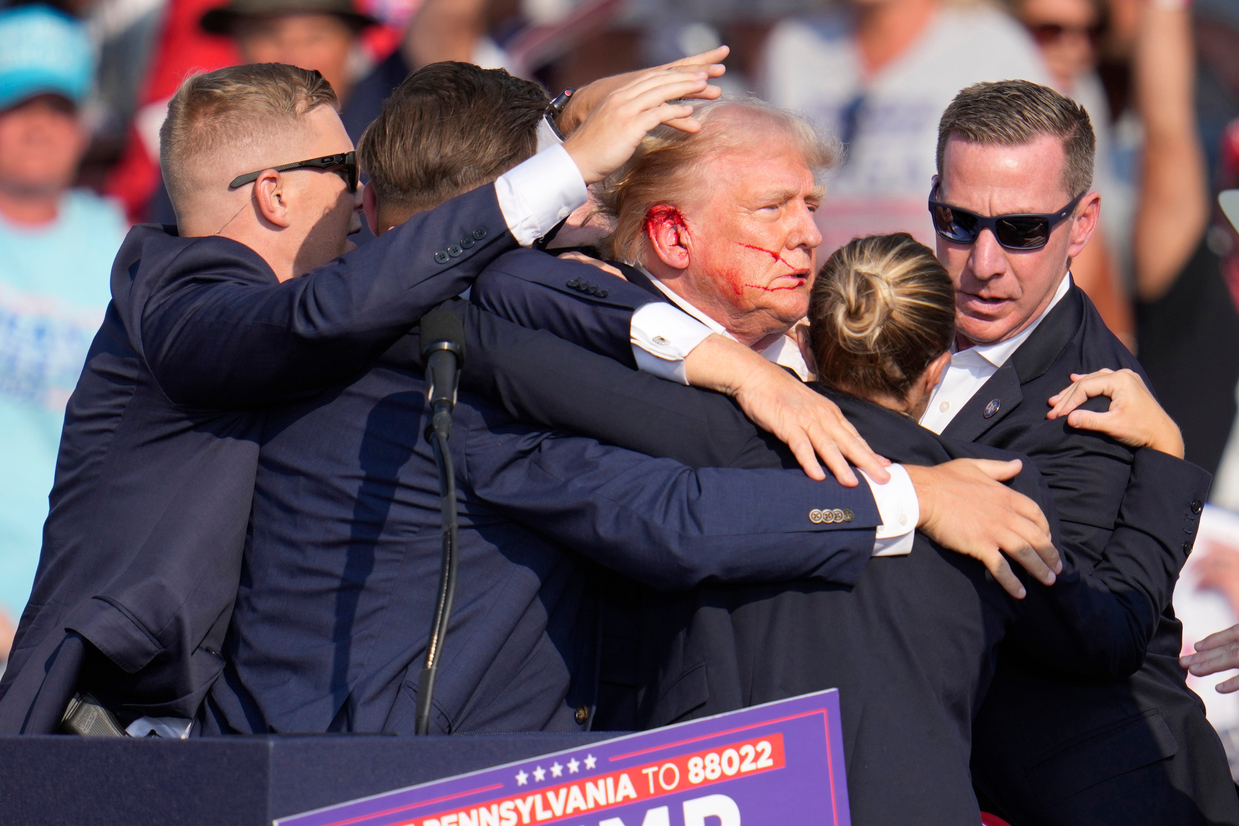 Republican presidential candidate and former president Donald Trump surrounded by Secret Service agents as he is helped off the stage after being shot at a campaign rally in Butler, Pennsylvania, on July 13. Photo: AP