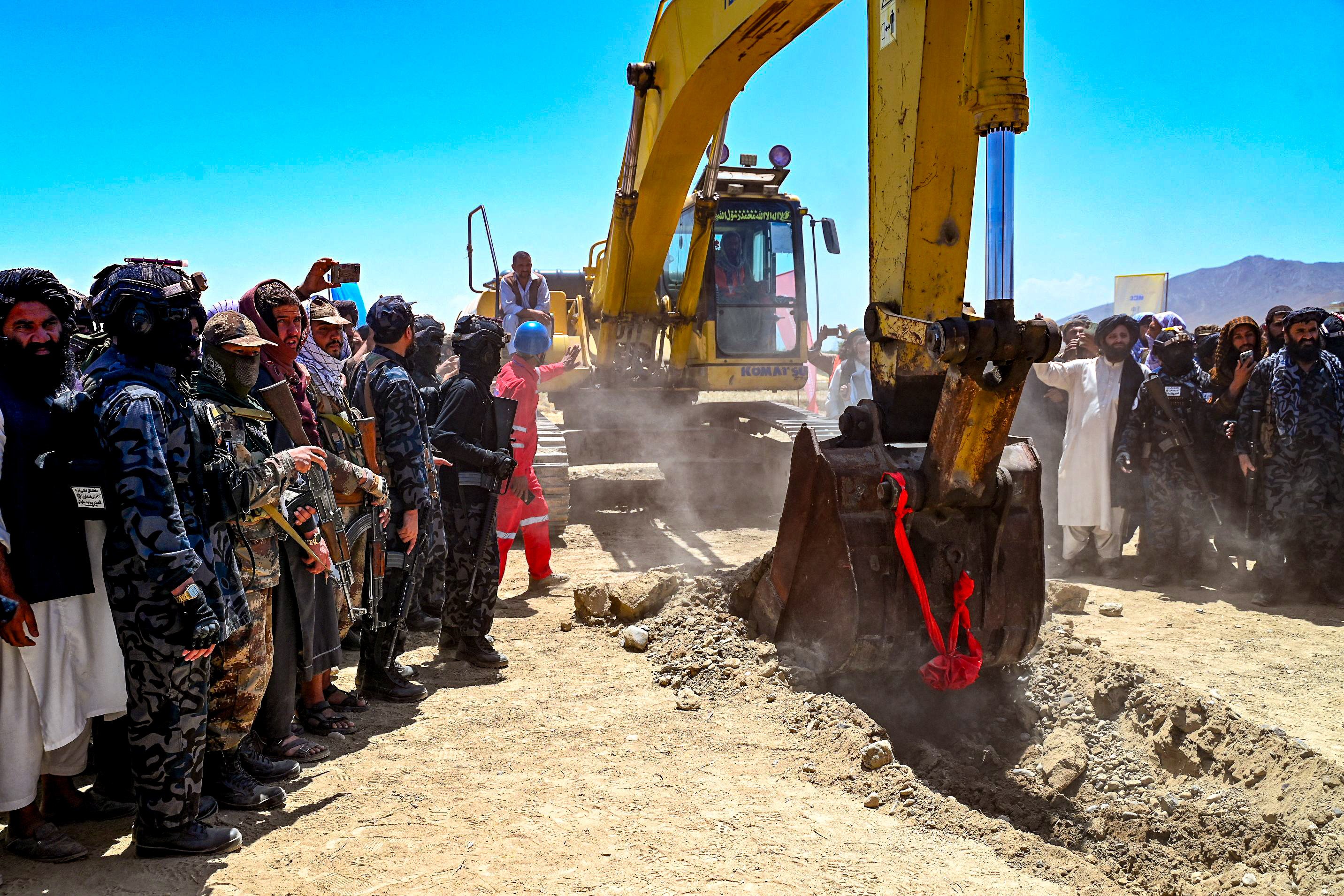 Taliban security personnel surround an excavator during the inauguration ceremony. Photo:  AFP