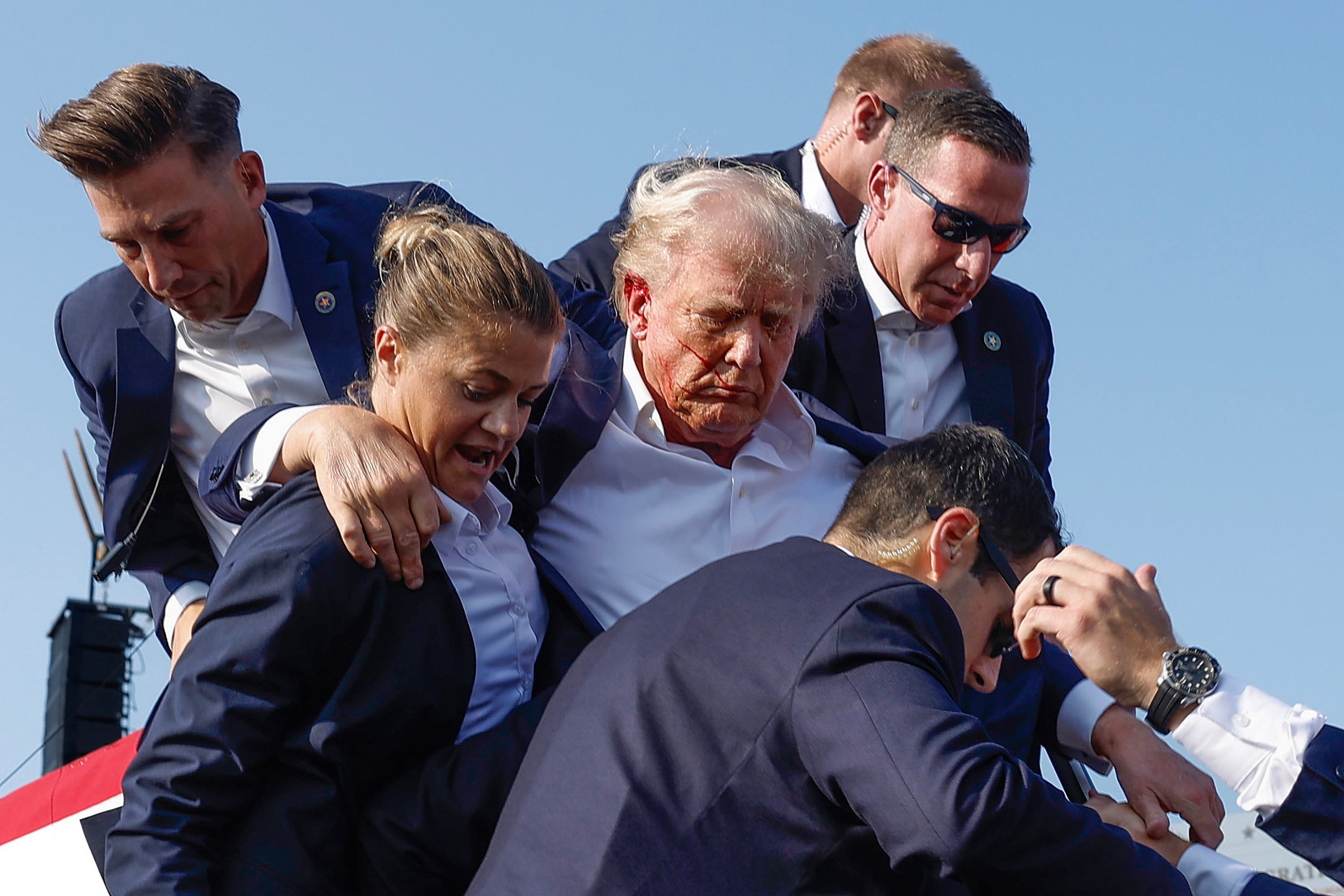Republican presidential candidate Donald Trump is rushed offstage by United States Secret Service agents after being grazed by a bullet during a failed assassination attempt in Butler, Pennsylvania, on July 13, 2024. Photo: Anna Moneymaker/Getty Images/TNS