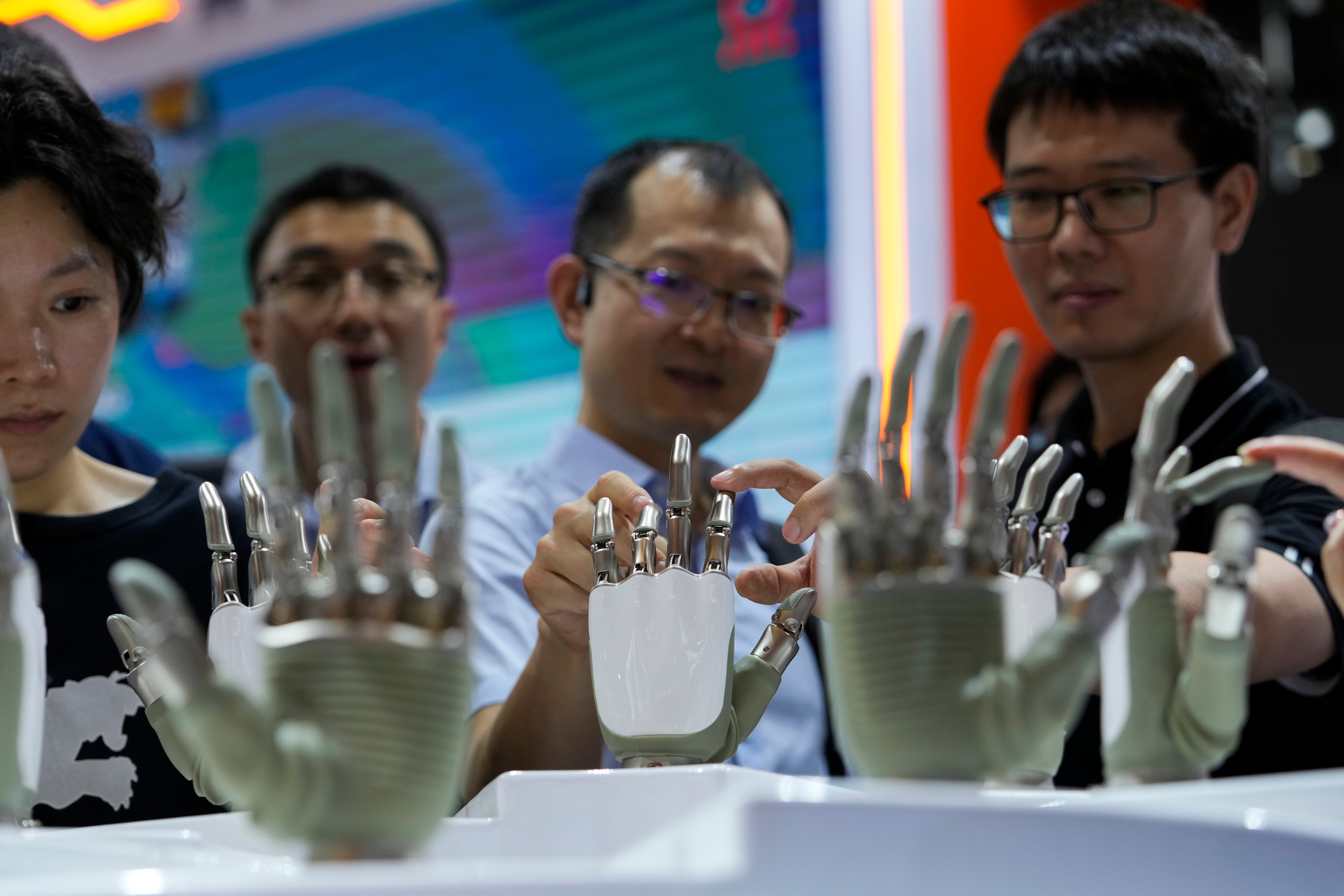Visitors touch humanoid robot hands on display at the World Artificial Intelligence Conference in Shanghai. Photo: AP