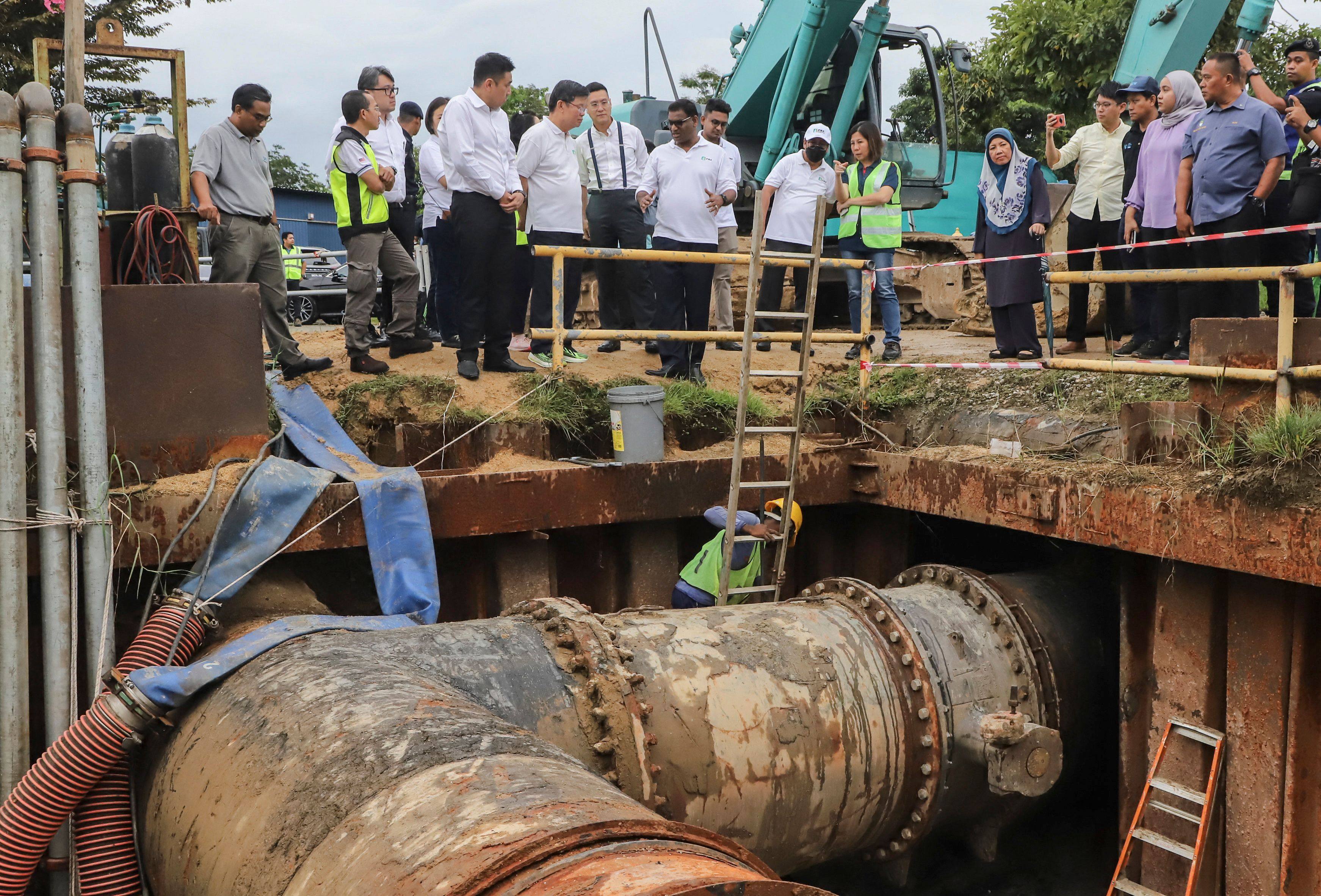 Workers replace water valves at the Sungai Dua water treatment plant as Penang’s Chief Minister Chow Kon Yeow inspects their progress in Penang on January 10. Photo: AFP