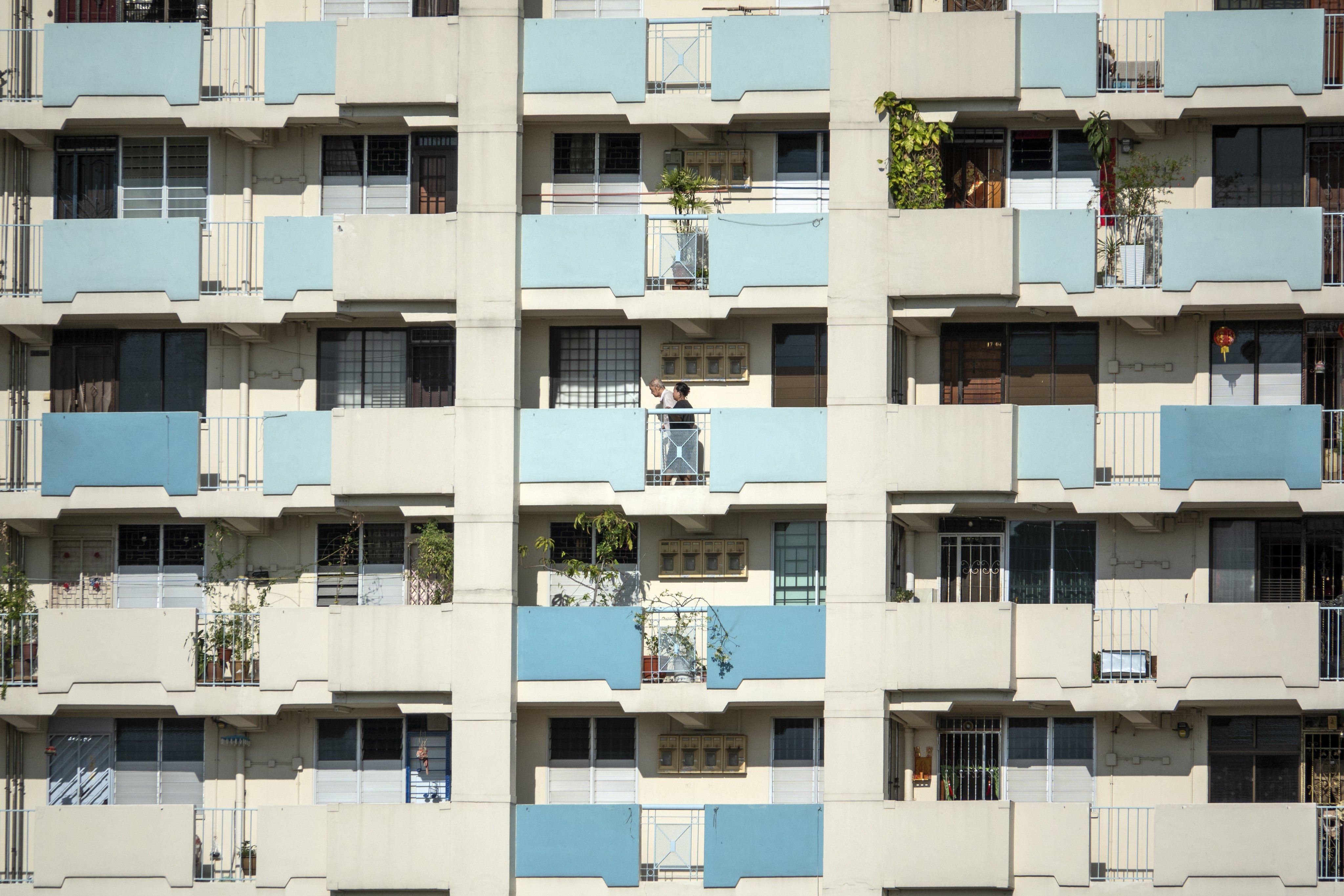 People walk along an external corridor at a Housing & Development Board (HDB) public housing estate in the Toa Payoh district of Singapore in April 2019. Photo: Bloomberg