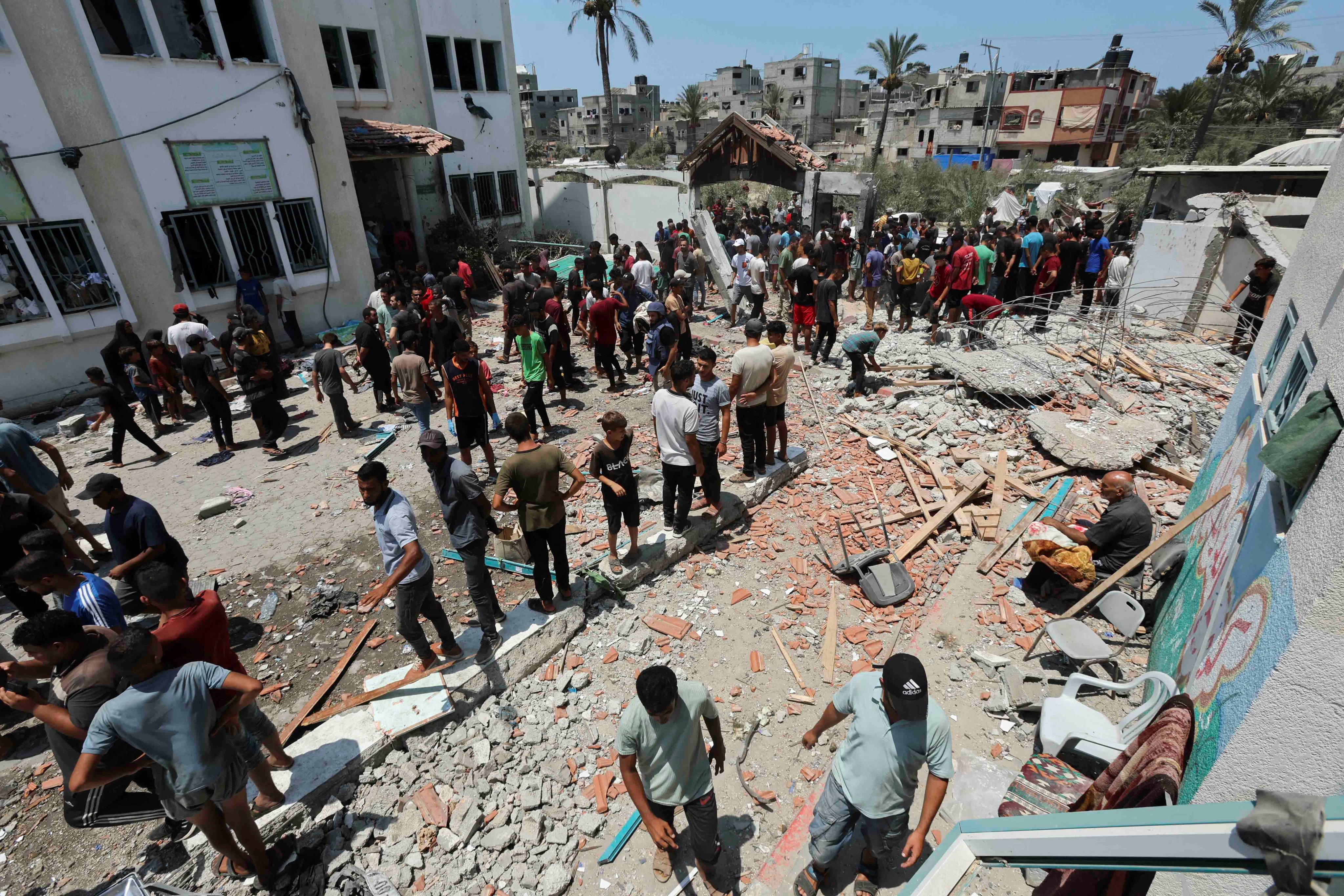 Palestinians inspect a school sheltering displaced people following an Israeli strike, amid the Israel-Hamas conflict, in Deir al-Balah in the central Gaza Strip on Saturday. Photo: Reuters