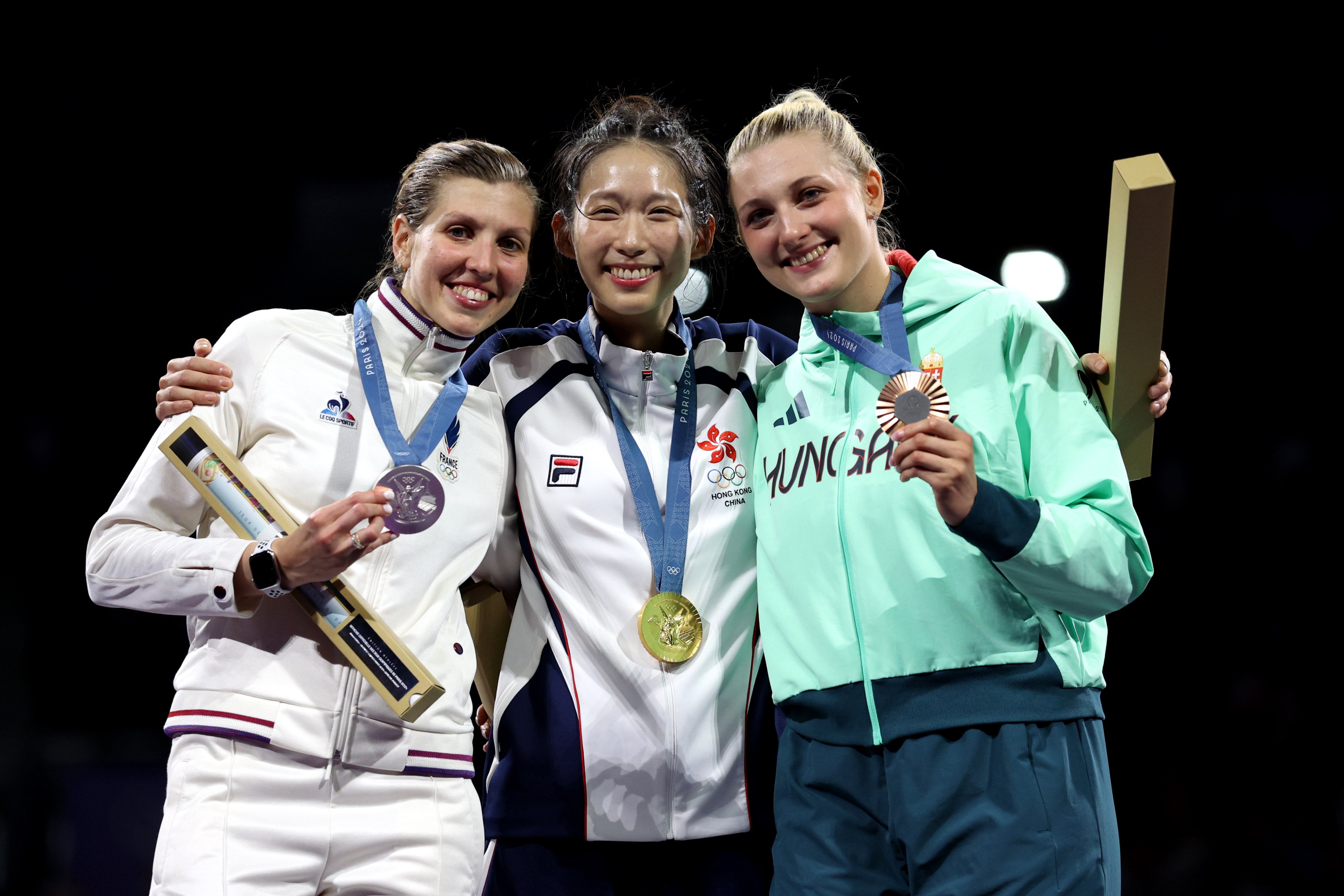 Gold medalist Vivian Kong (centre), alongside silver medalist Auriane Mallo-Breton (left) and bronze medalist Eszter Muhari of Hungary celebrate on the podium at Grand Palais in Paris. Photo: Getty Images