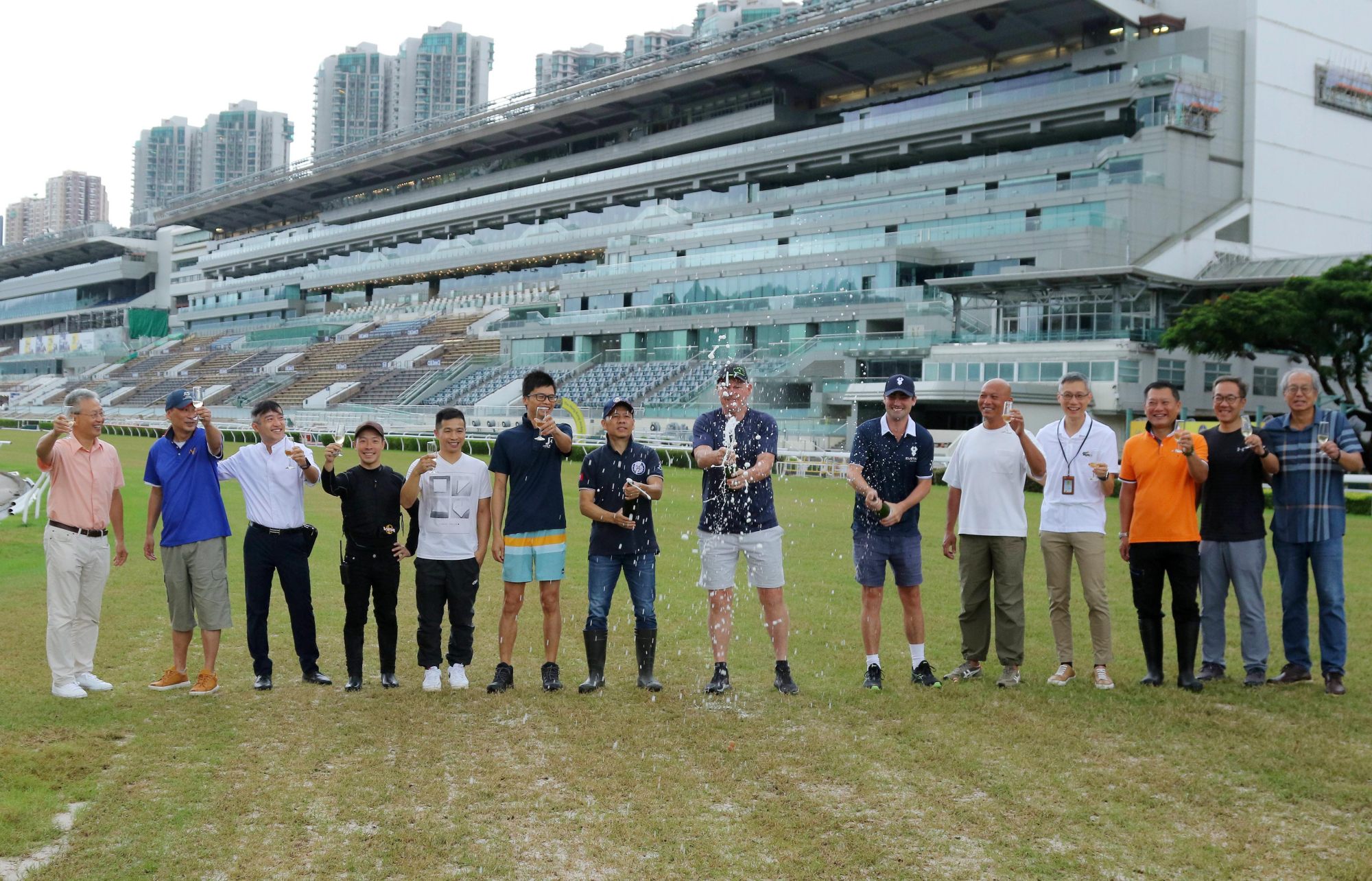 Trainers, assistant trainers and Jockey Club officials toast the reopening of trackwork at Sha Tin.