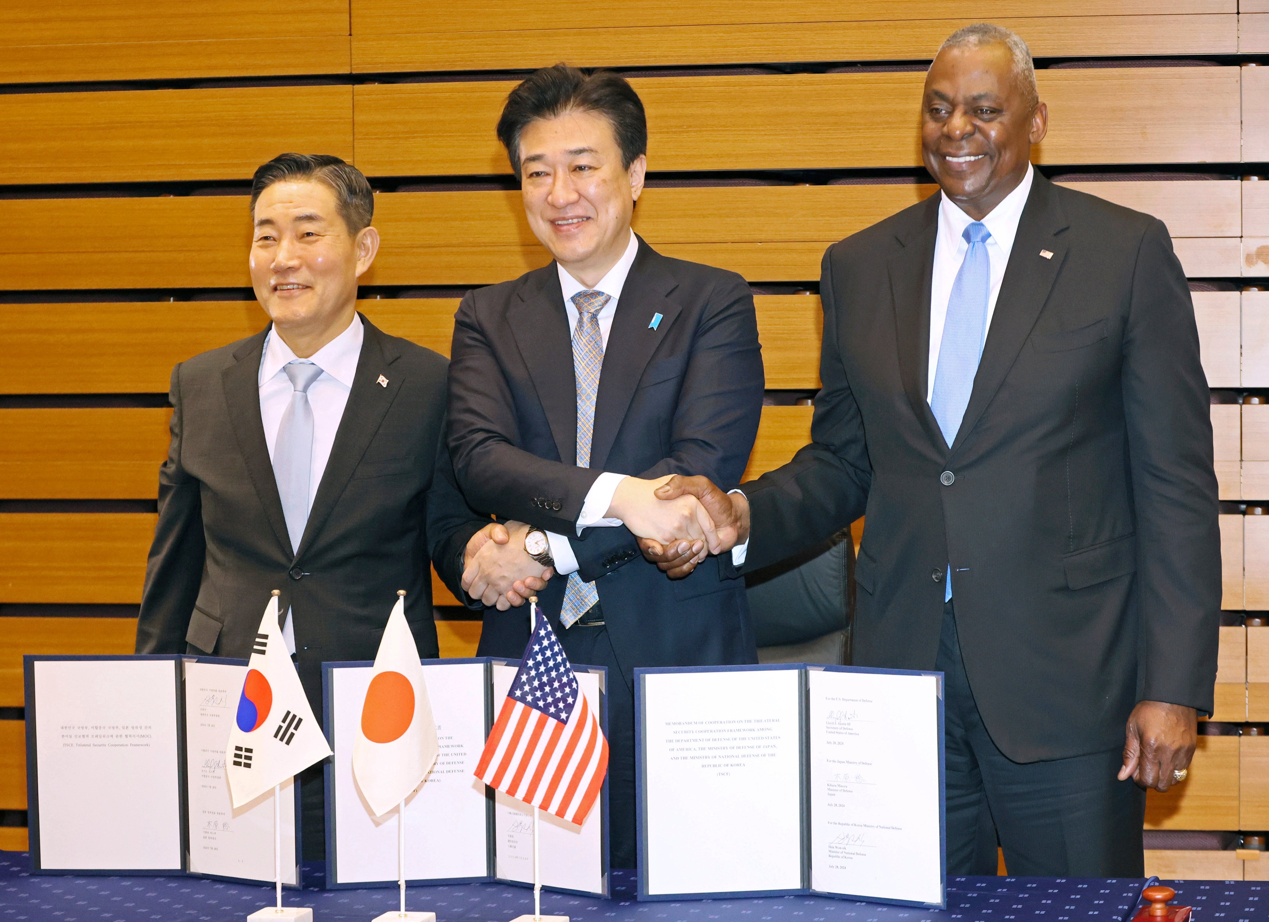 (From left) South Korean Defence Minister Shin Won-sik, Japanese Defence Minister Minoru Kihara and US Secretary of Defence Lloyd Austin shake hands after a trilateral defence ministers’ meeting in Tokyo on Sunday. Photo: Pool via AP