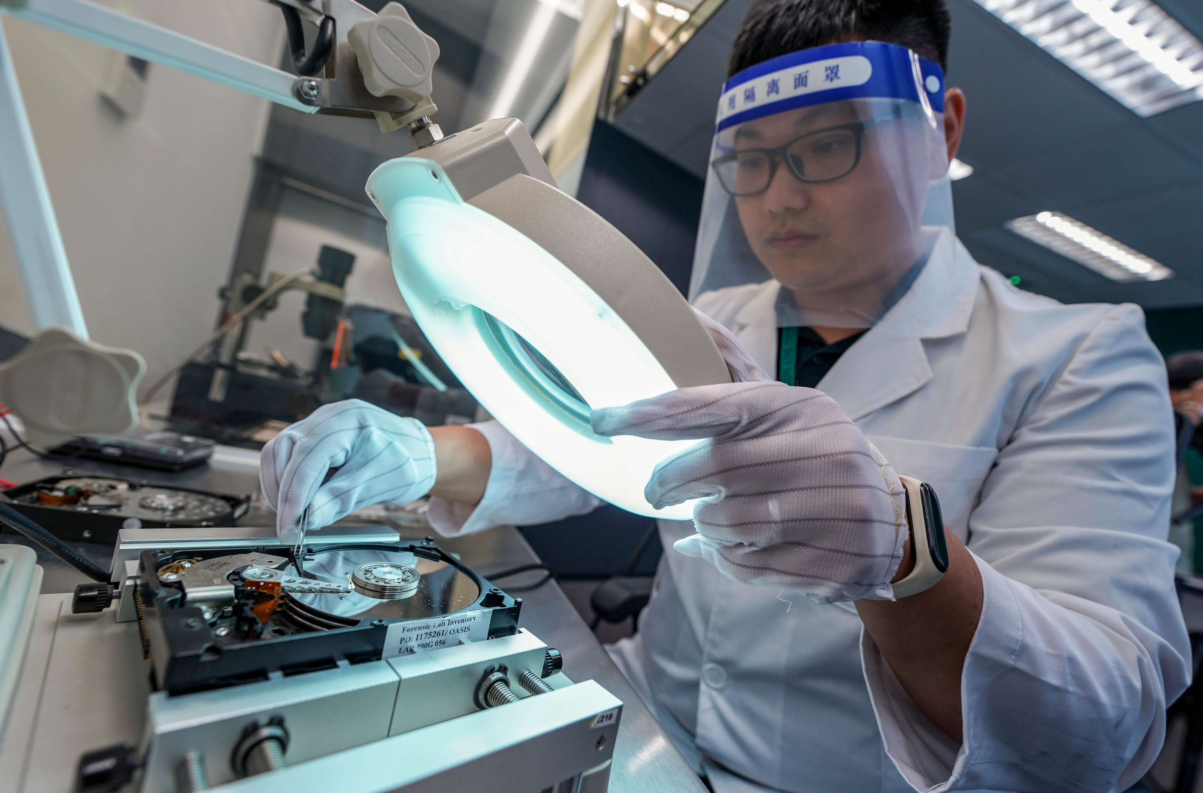 A lab technician demonstrates a hard disk drive inspection at customs’ computer forensic lab in North Point. Photo: Eugene Lee