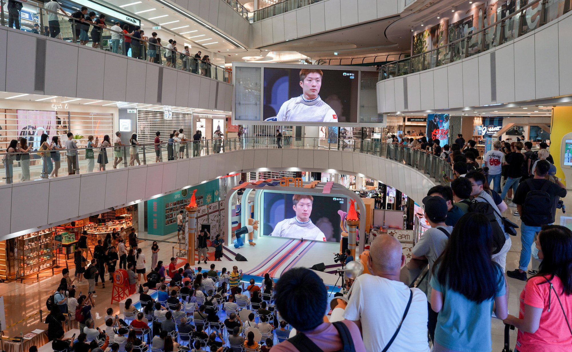 People in a Kwun Tong shopping centre cheer for Hong Kong fencer Cheung Ka-long. Photo: Eugene Lee