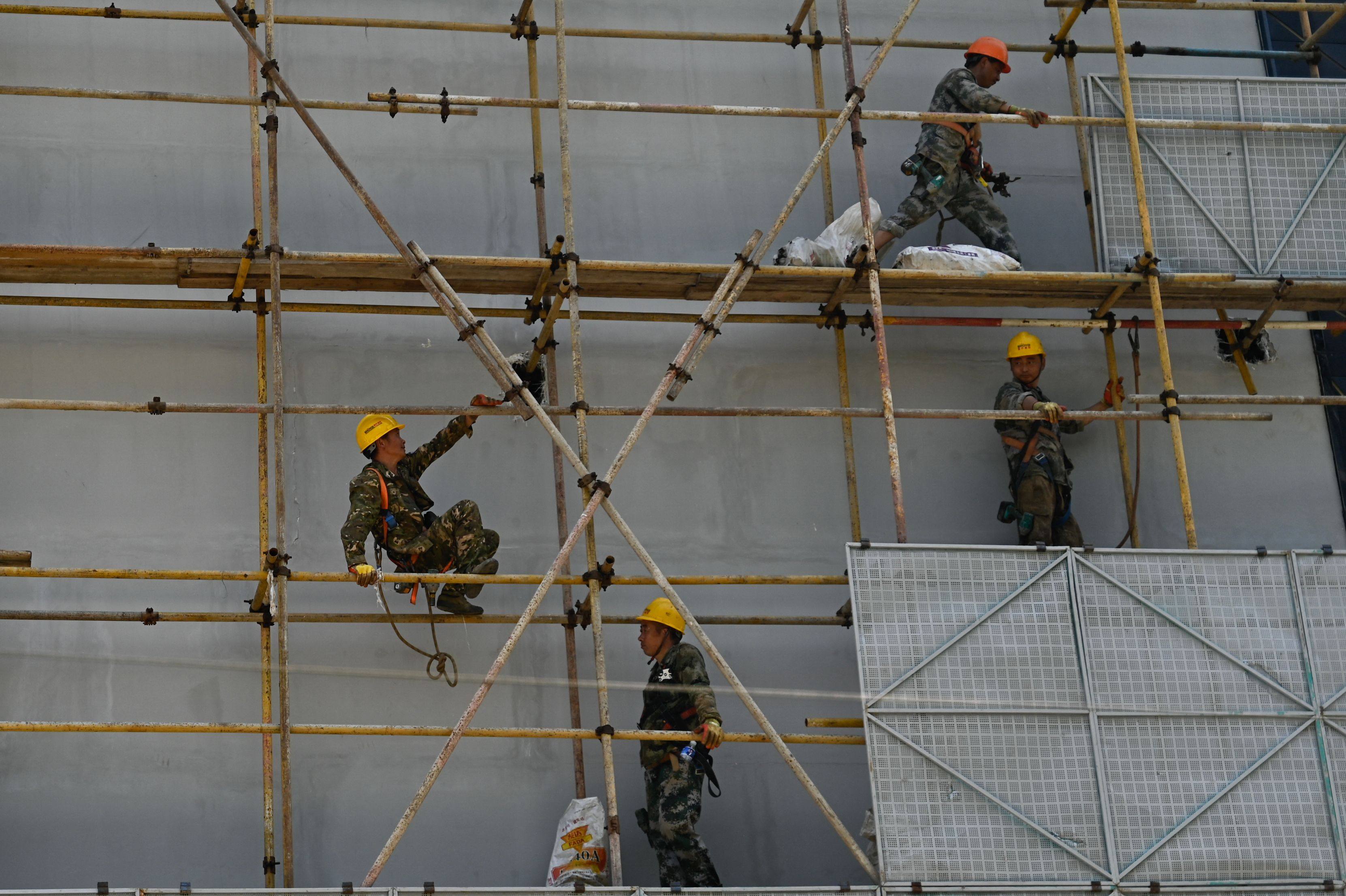 A construction team works on a store facade in Beijing. Photo: AFP