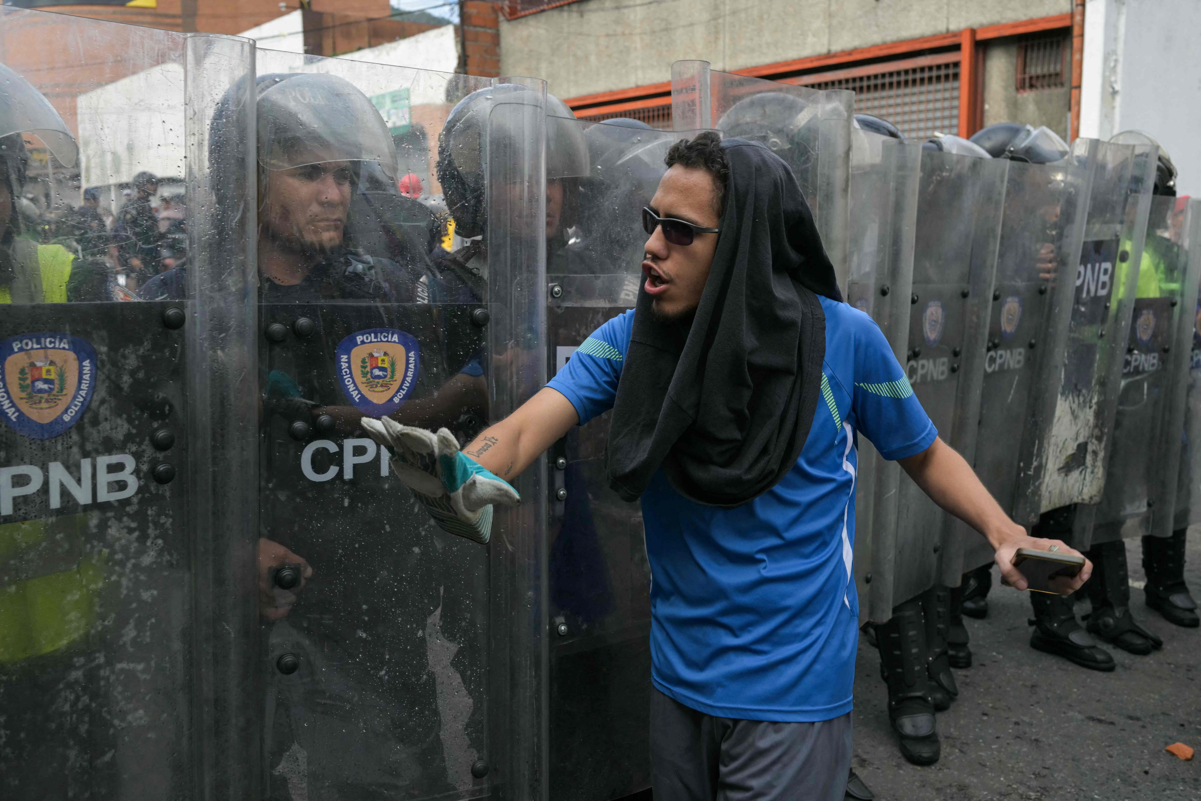 A demonstrator walks in front of police officers during a protest against Venezuelan President Nicolas Maduro’s government in Caracas. Photo: AFP