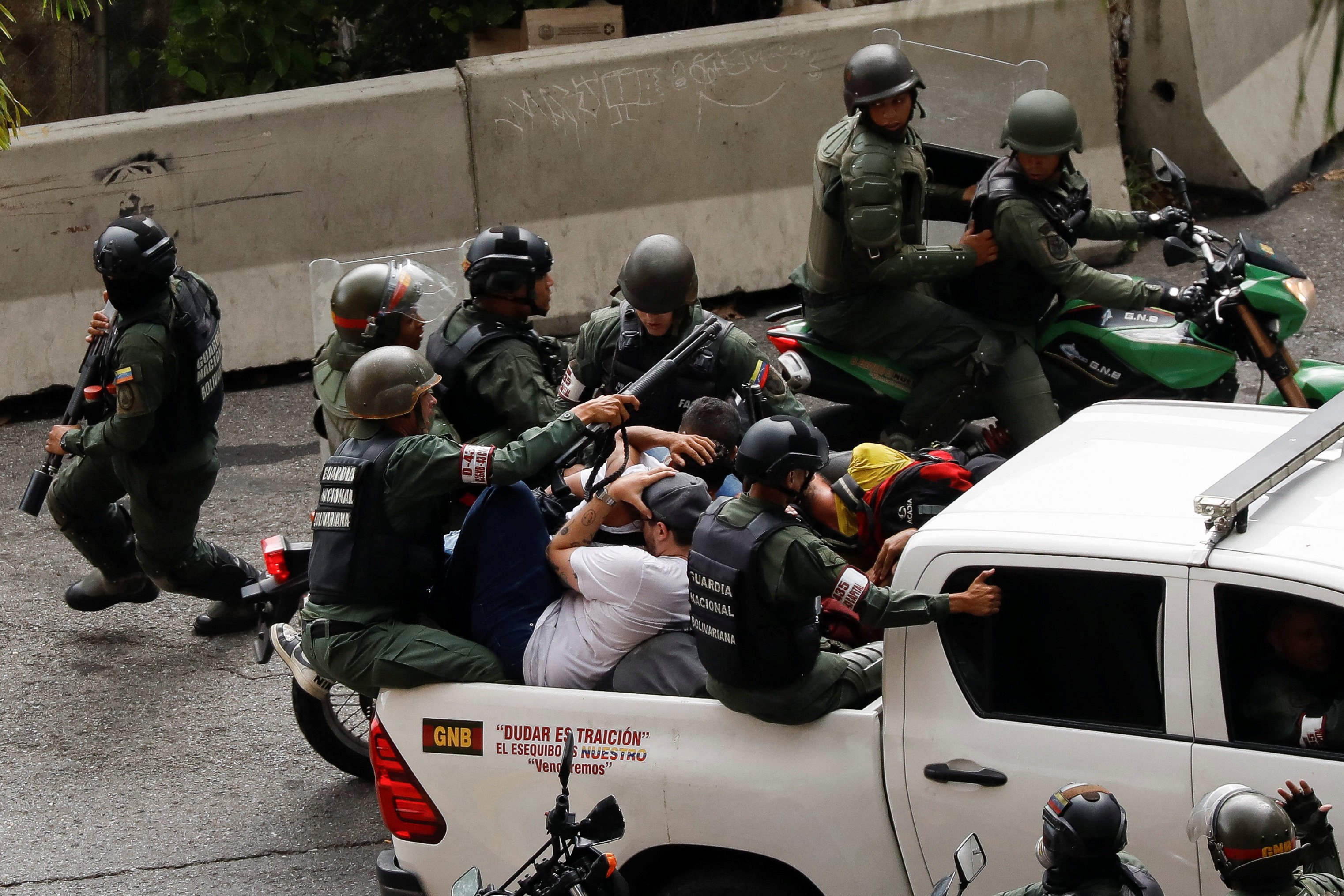 Bolivarian National Guard detain demonstrators in Caracas, Venezuela. Photo: Reuters