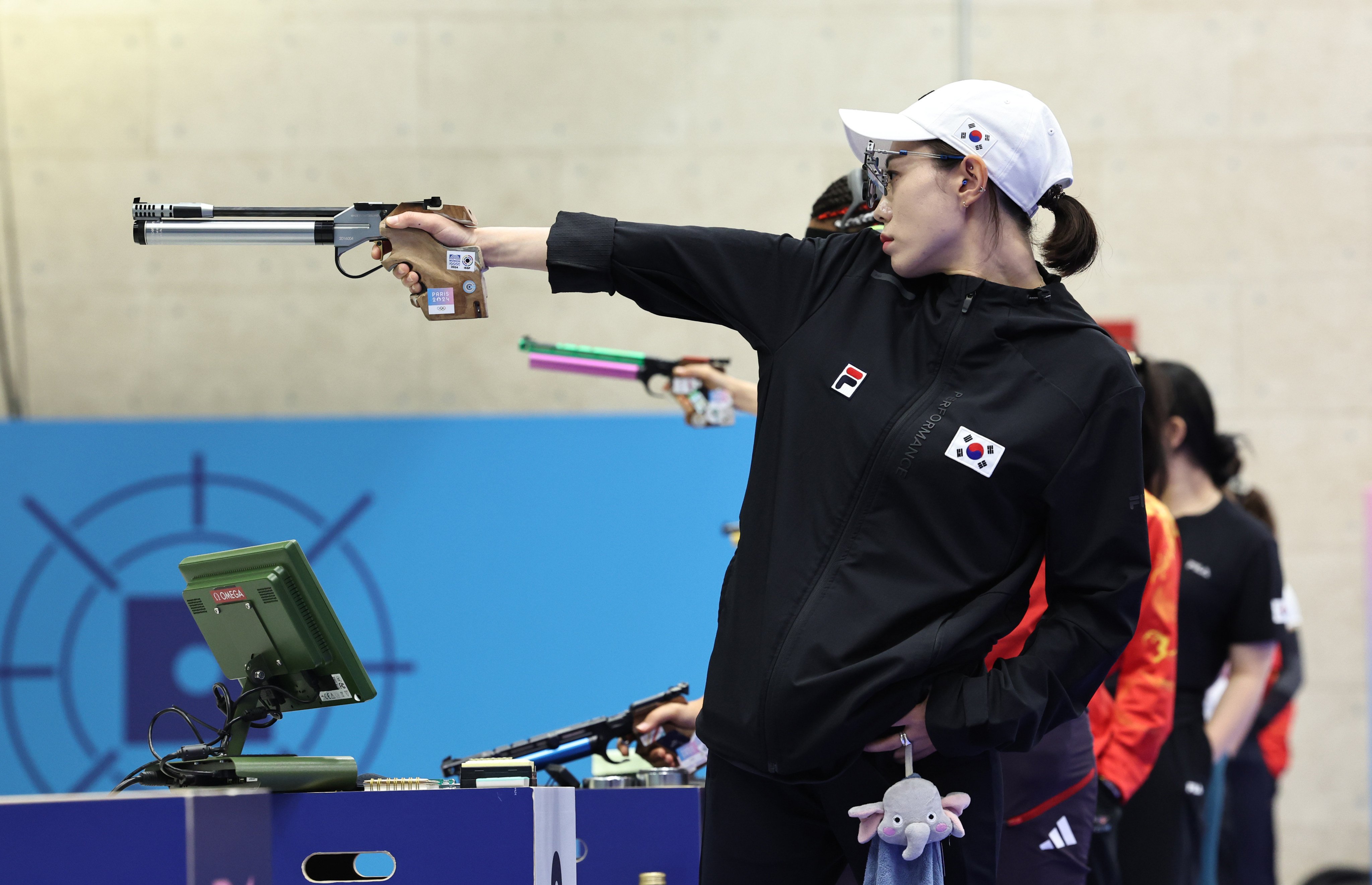 South Korea’s Kim Ye-ji competing in the 10m air pistol women’s final while carrying a stuffed elephant that reportedly belongs to her daughter. Photo: Xinhua