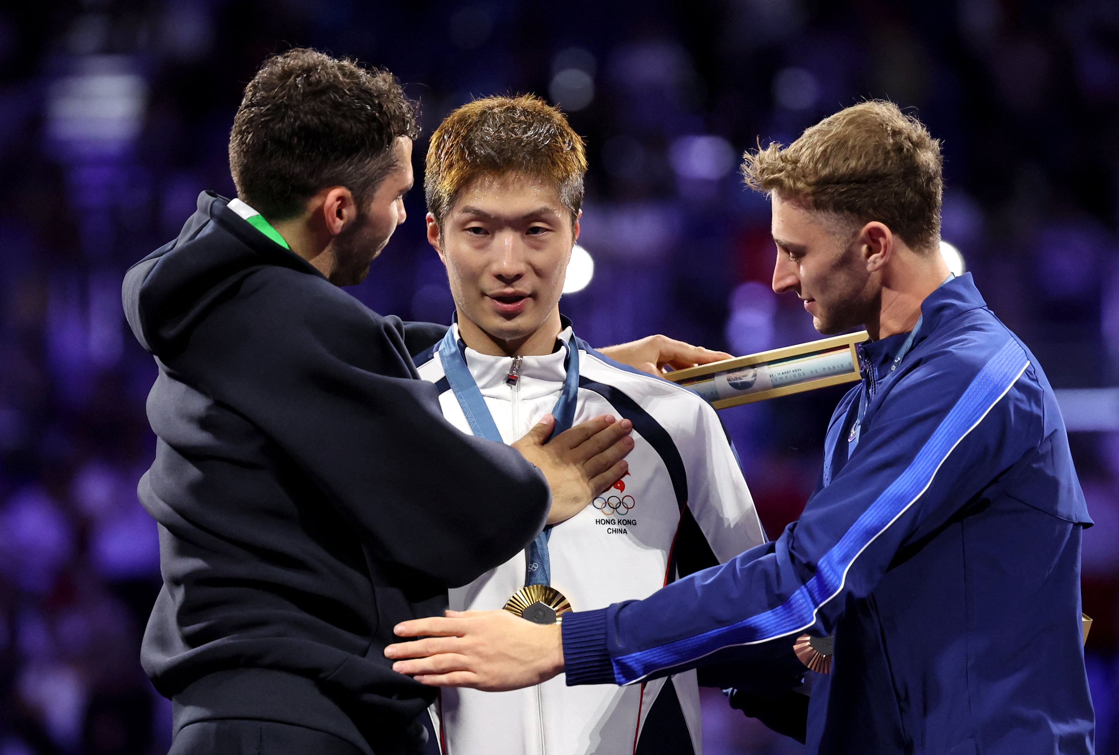 Gold medalist Ka Long Cheung of Hong Kong celebrates with silver medalist Filippo Macchi of Italy and bronze medalist Nick Itkin of United States after winning. Photo: Reuters