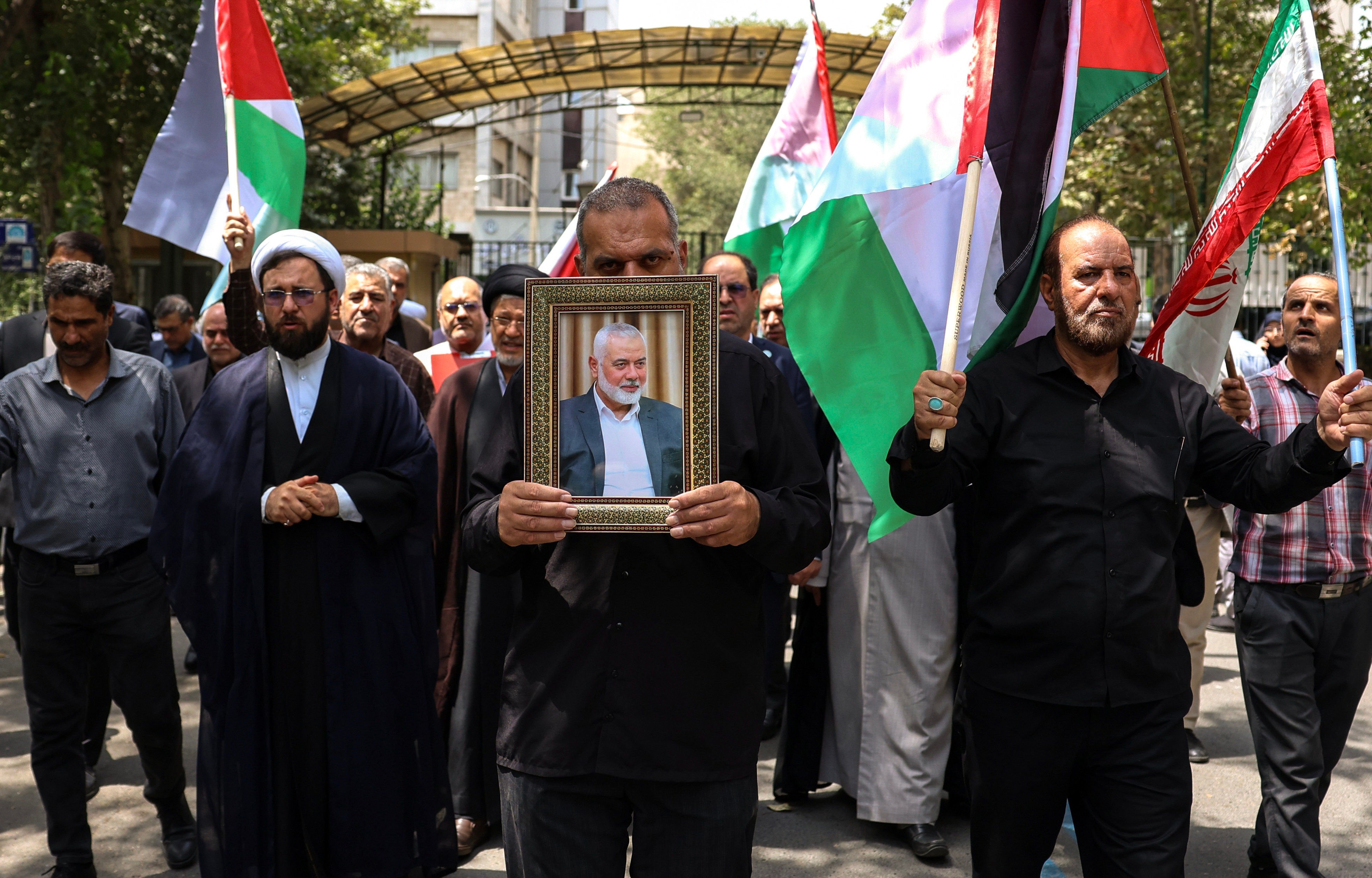 Protesters carry a portrait of late Hamas political leader Ismail Haniyeh at Tehran University on Wednesday. Photo: EPA-EFE