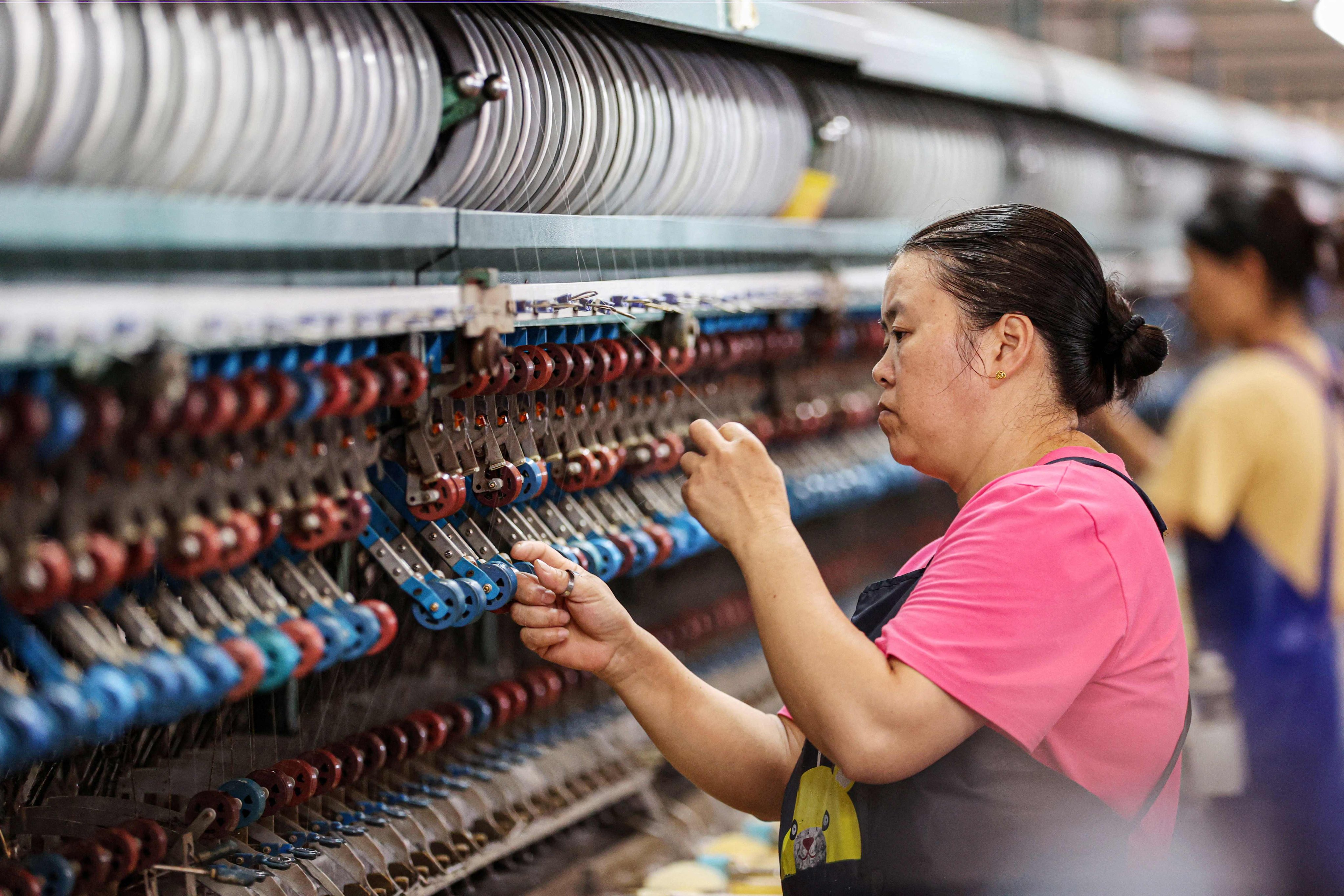 A worker produces silk products at the factory of a silk company in southeastern China’s Chongqing municipality. Photo: AFP