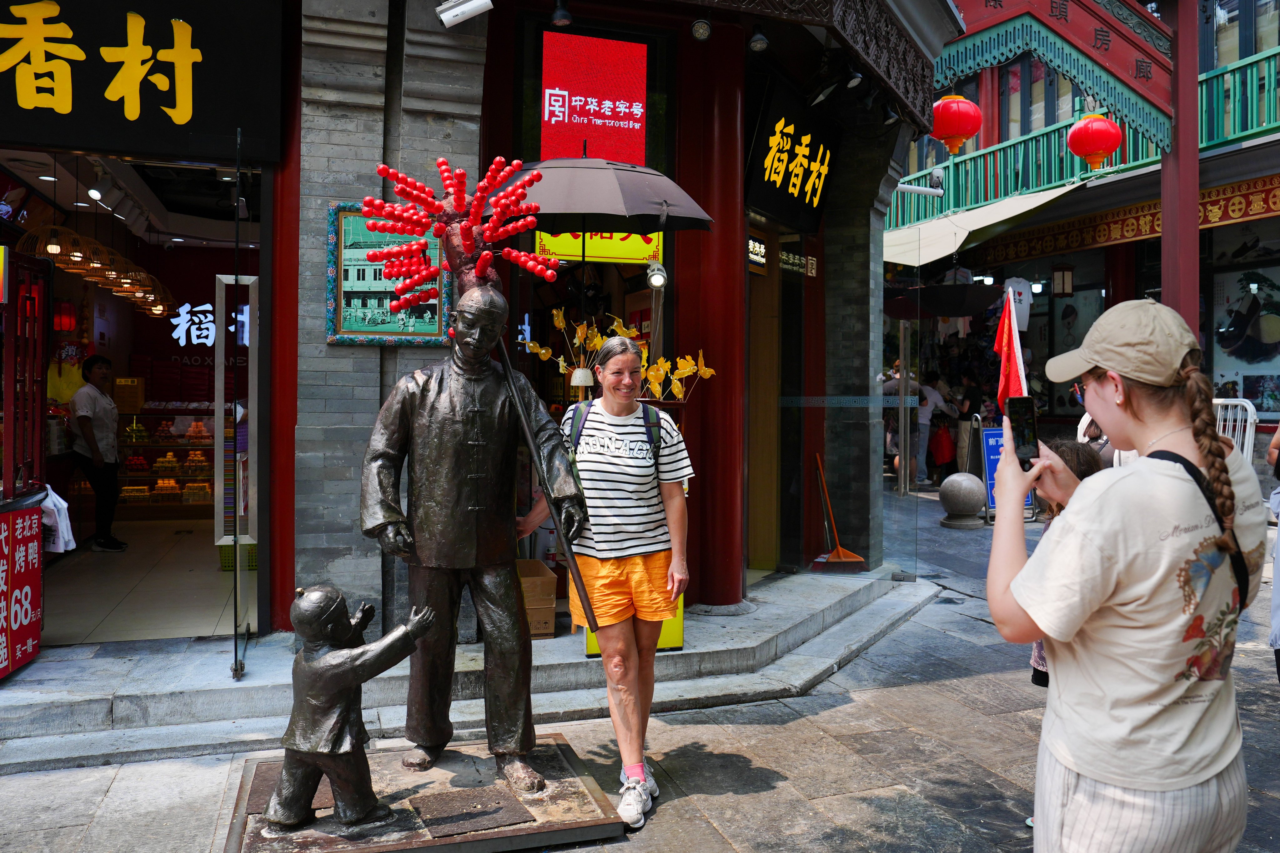 A tourist poses for a photo on Qianmen Street in Beijing. Photo: Xinhua