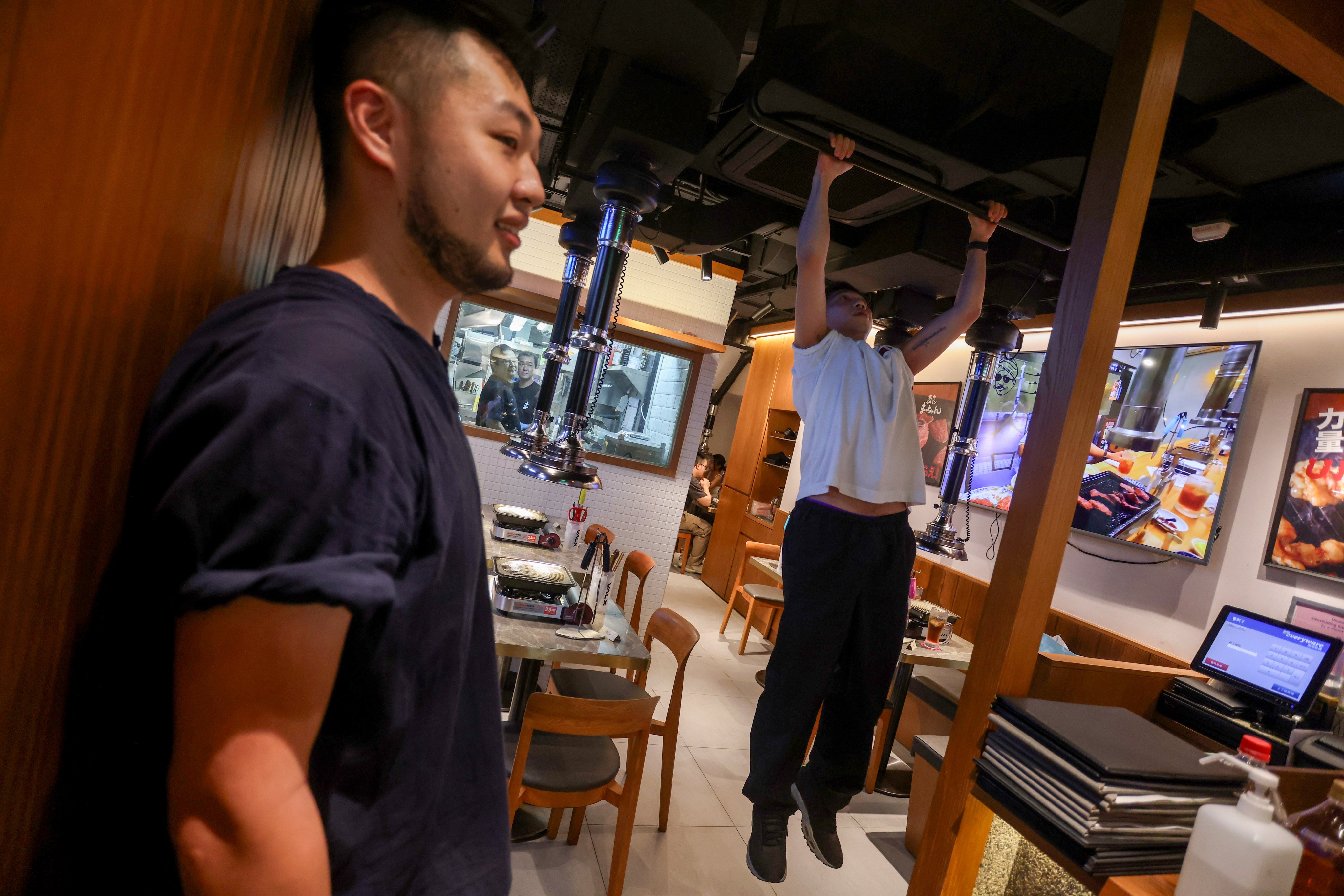 A patron uses the pull-up bar at Yakiniku Horumon Matchan to earn a free meat serving. It’s one of five food and drink experiences in Hong Kong we recommend this weekend. Photo: Jonathan Wong 