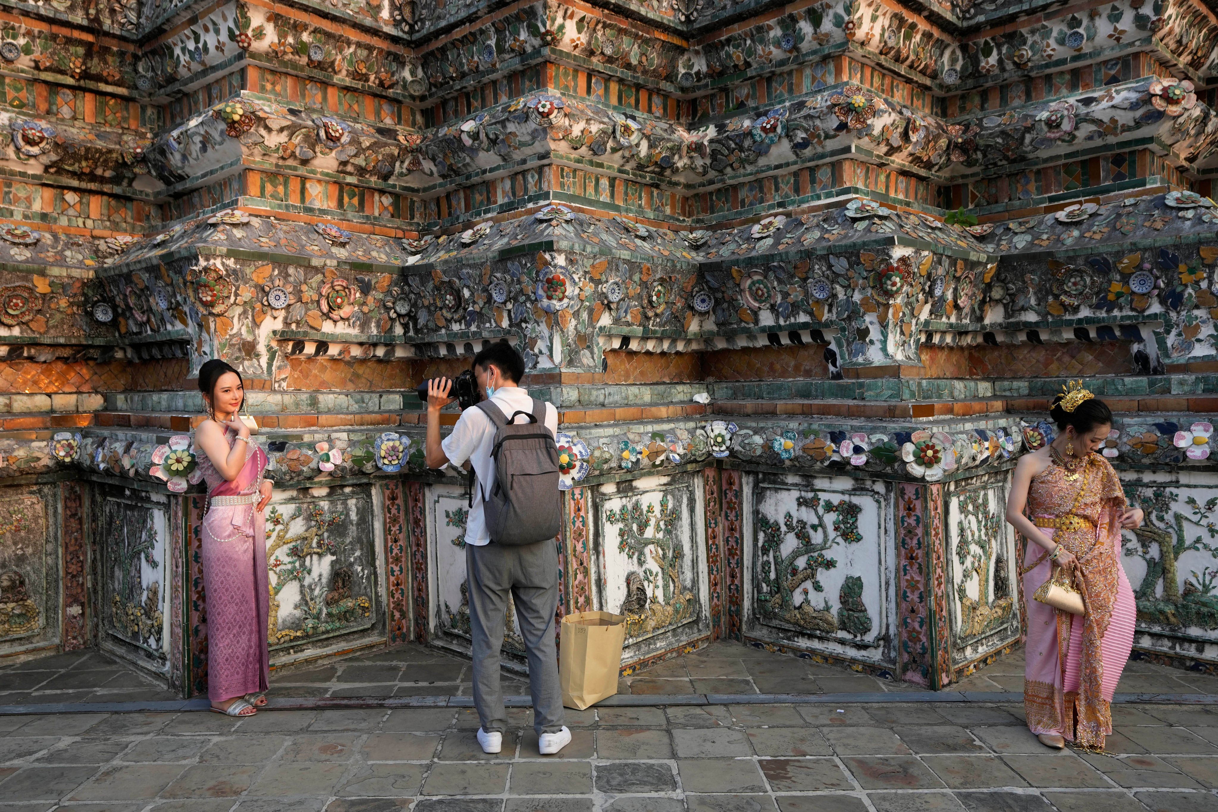 A Chinese tourist in traditional Thai dress poses for a photo at Wat Arun or the Temple of Dawn in Bangkok in 2023. Photo: AP 
