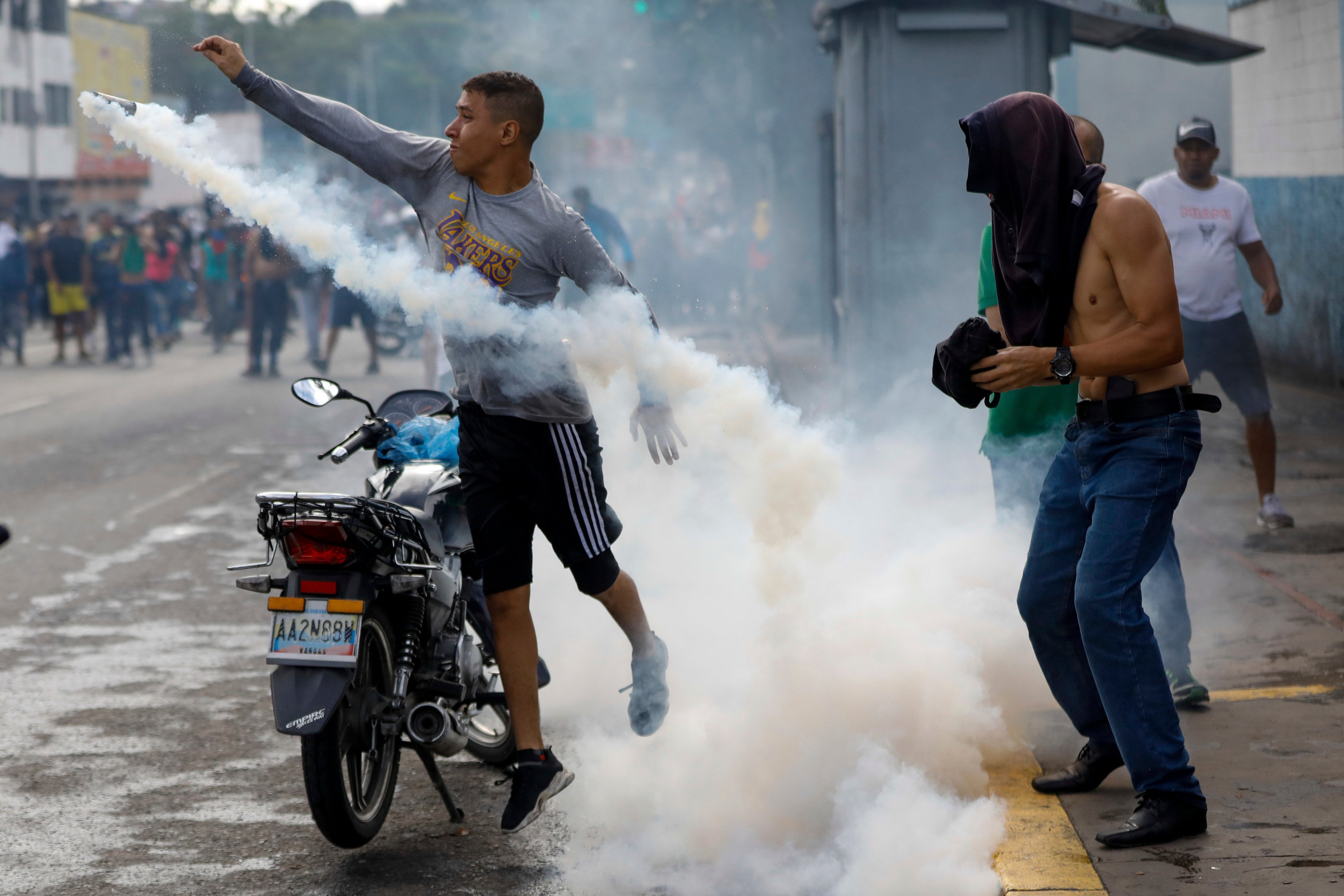 A protester throws a smoke canister back at police on Monday. Photo: AP