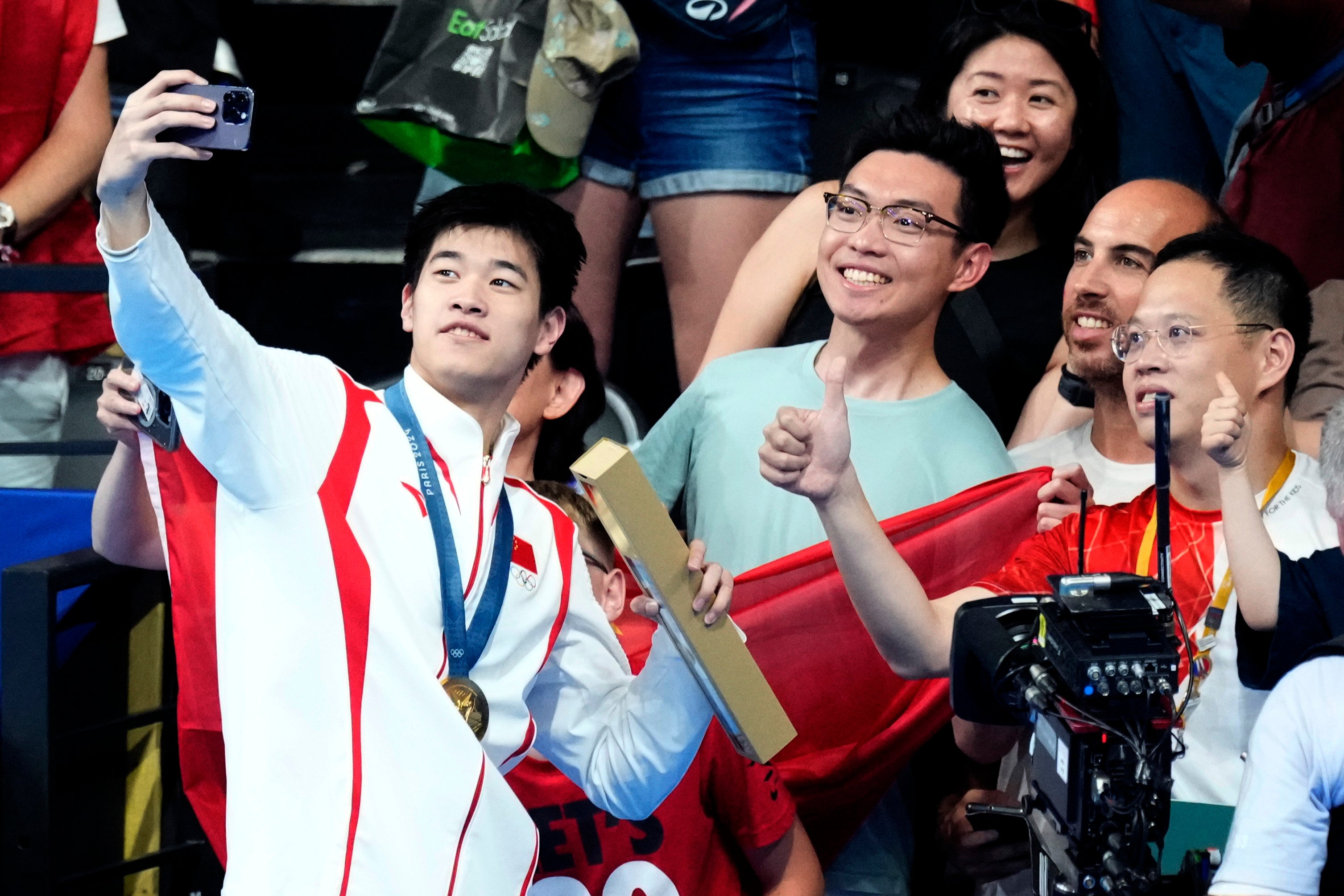 China’s gold medallist Pan Zhanle takes a selfie with fans after stunning victory in the 100 metres freestyle. Photo: AP