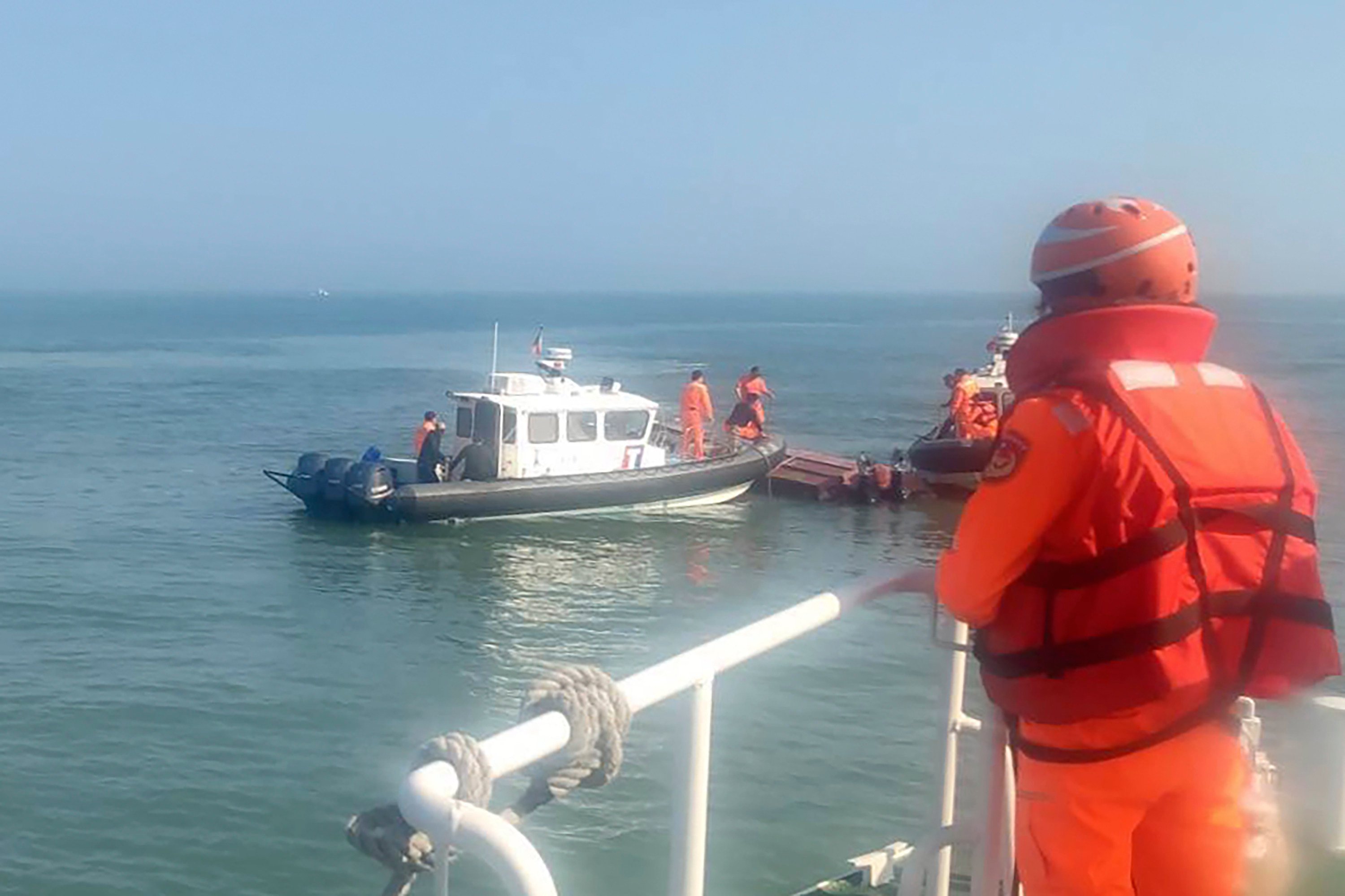 Taiwanese coastguards inspect a vessel that capsized during a chase off the coast of the Quemoy archipelago on February 14. Photo: Taiwan Coast Guard Administration via AP