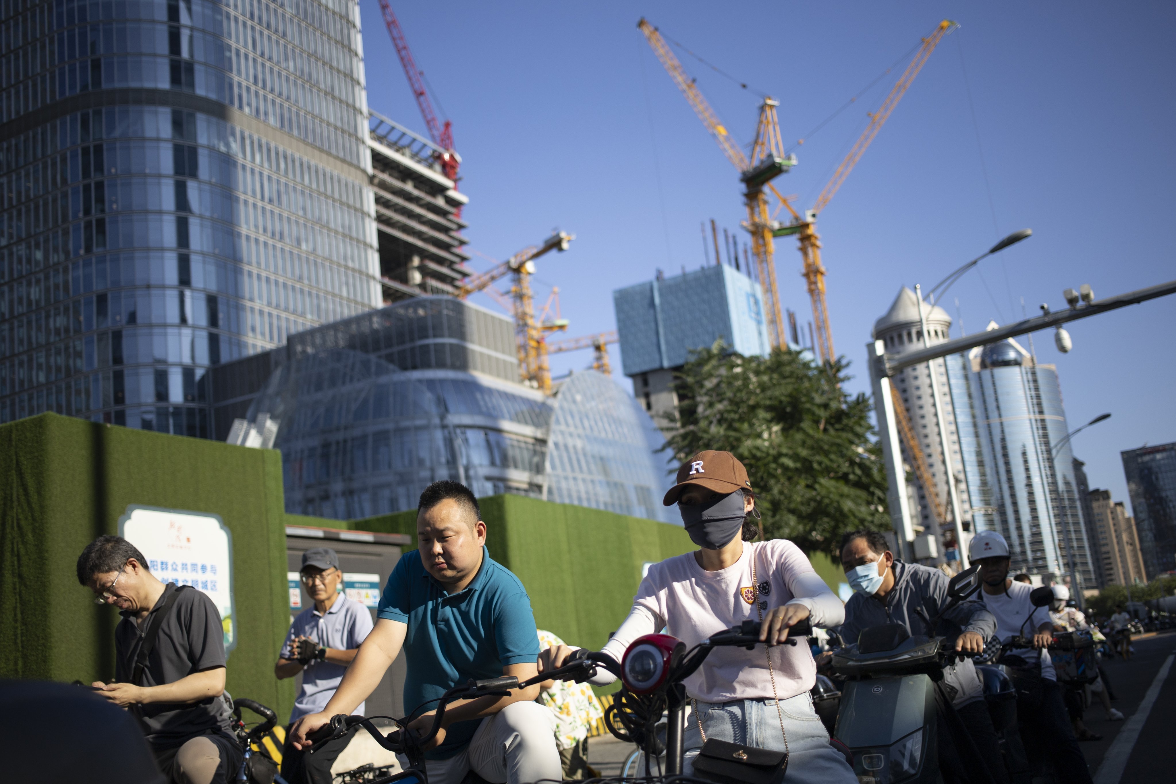 Cyclists and construction in Beijing on July 18. Municipalities’ dependence on land sales for revenue is one of the main factors behind China’s property bubble. Photo: EPA-EFE