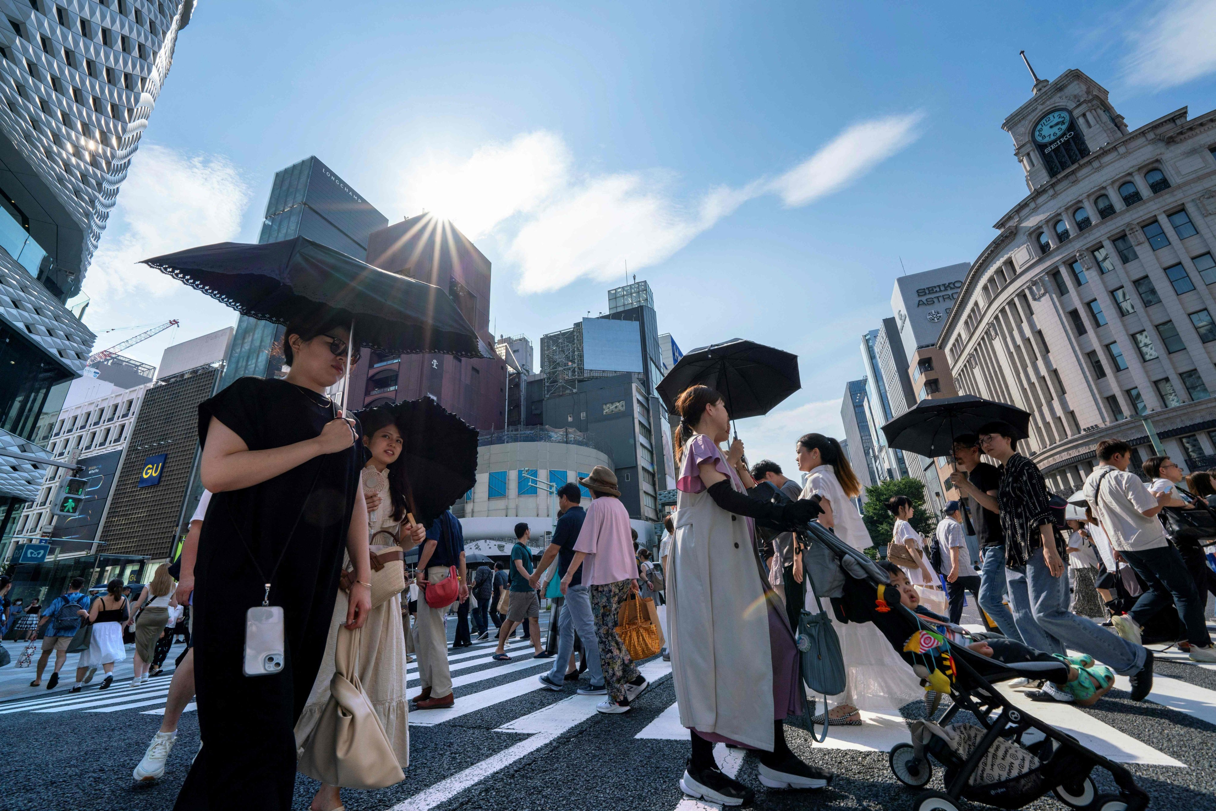 Pedestrians walk on a crossing in Tokyo where temperatures have topped 35 degrees Celsius on July 8. Photo: AFP