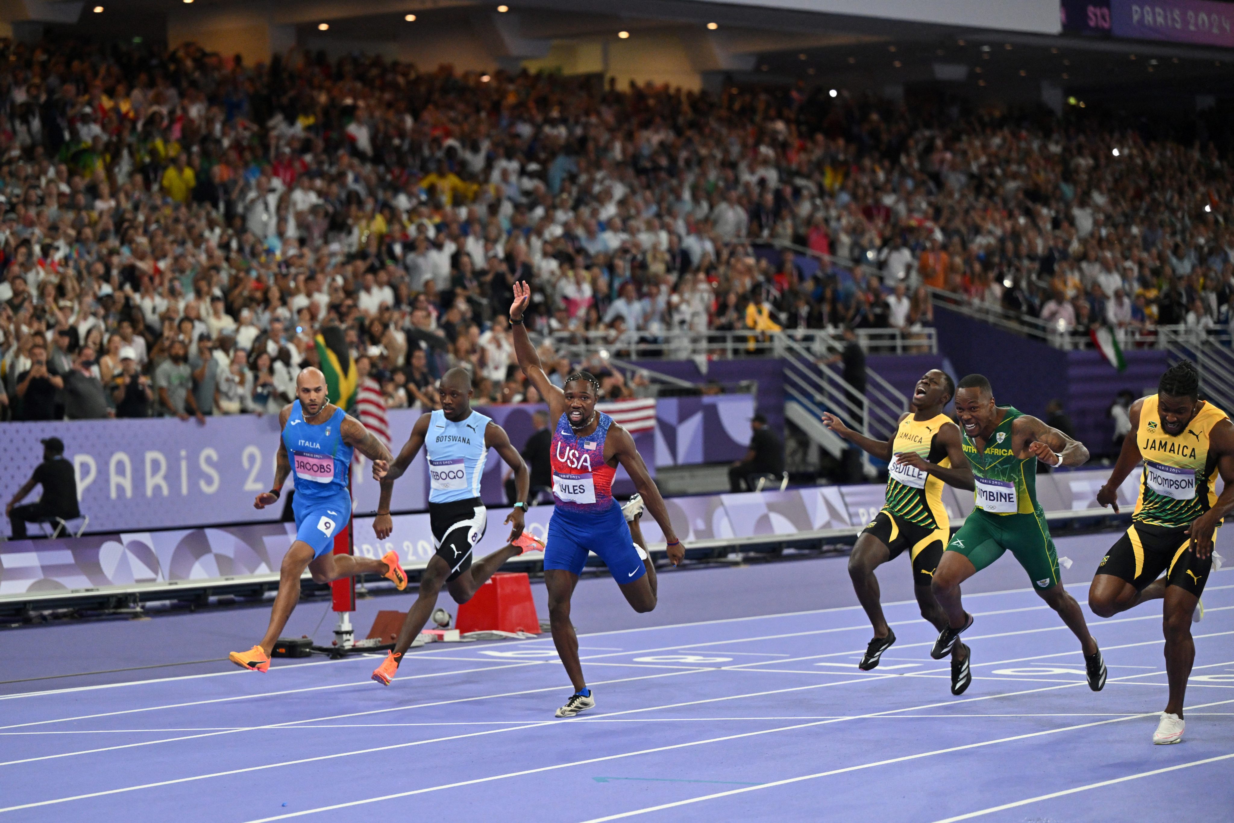 US’ Noah Lyles raises an arm as he crosses the finish in the men’s 100m final in Paris. Photo: AFP