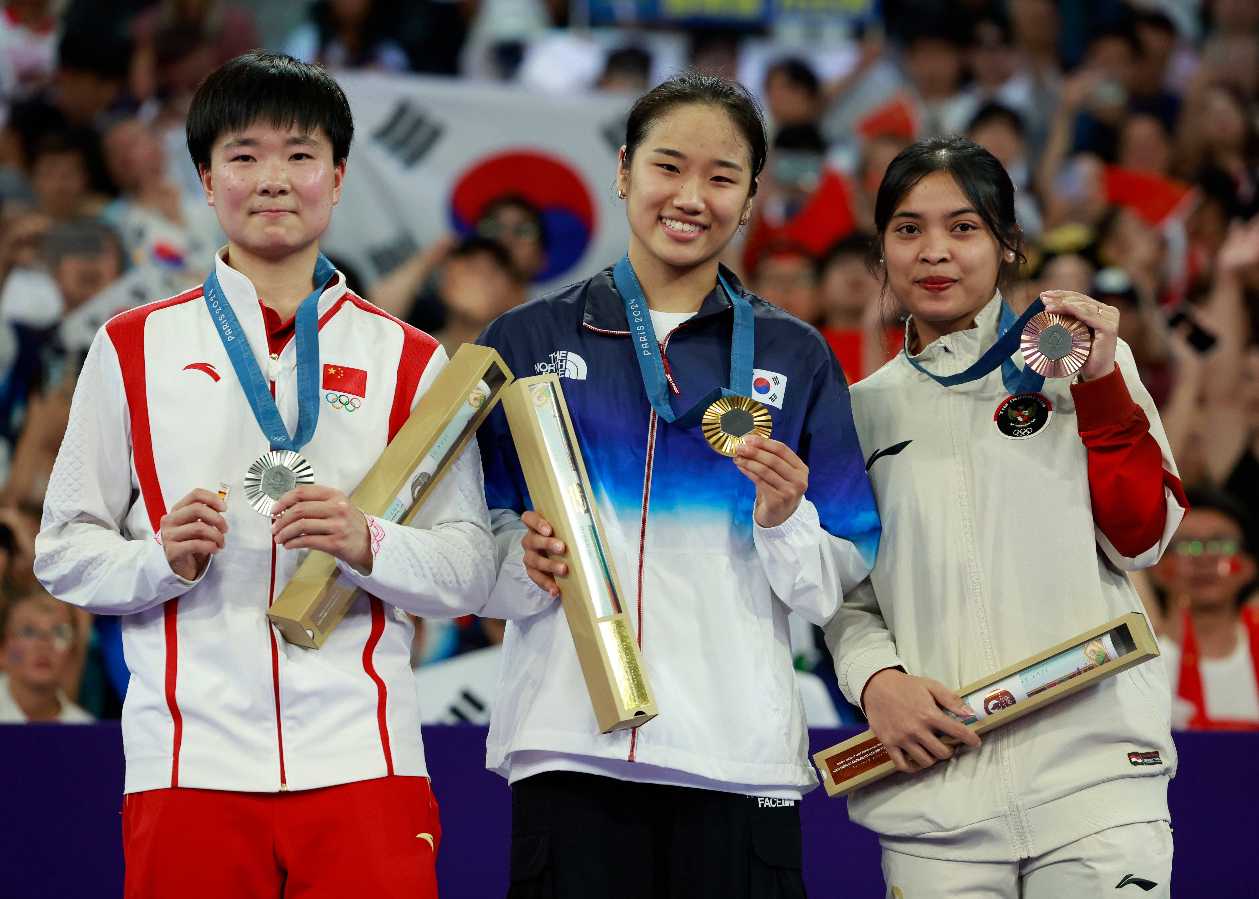 China’s He Bingjiao (left) holds a small pin of the Spanish flag in her right hand while standing on the podium next to An Se-young (centre) and Gregoria Mariska Tunjung: Photo: Xinhua