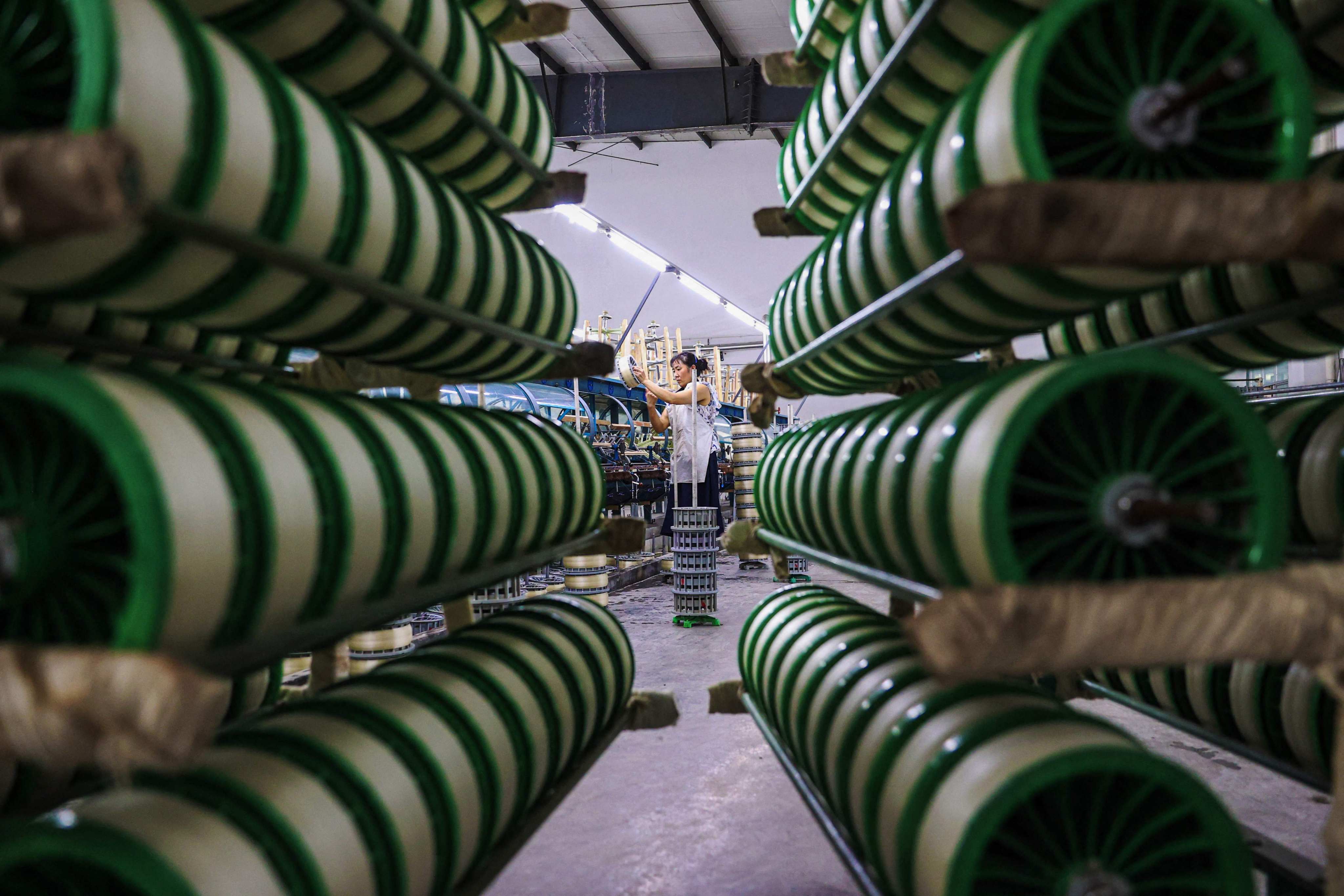 A worker produces silk products at a factory of a silk company in southeastern China’s Chongqing municipality. Photo: AFP