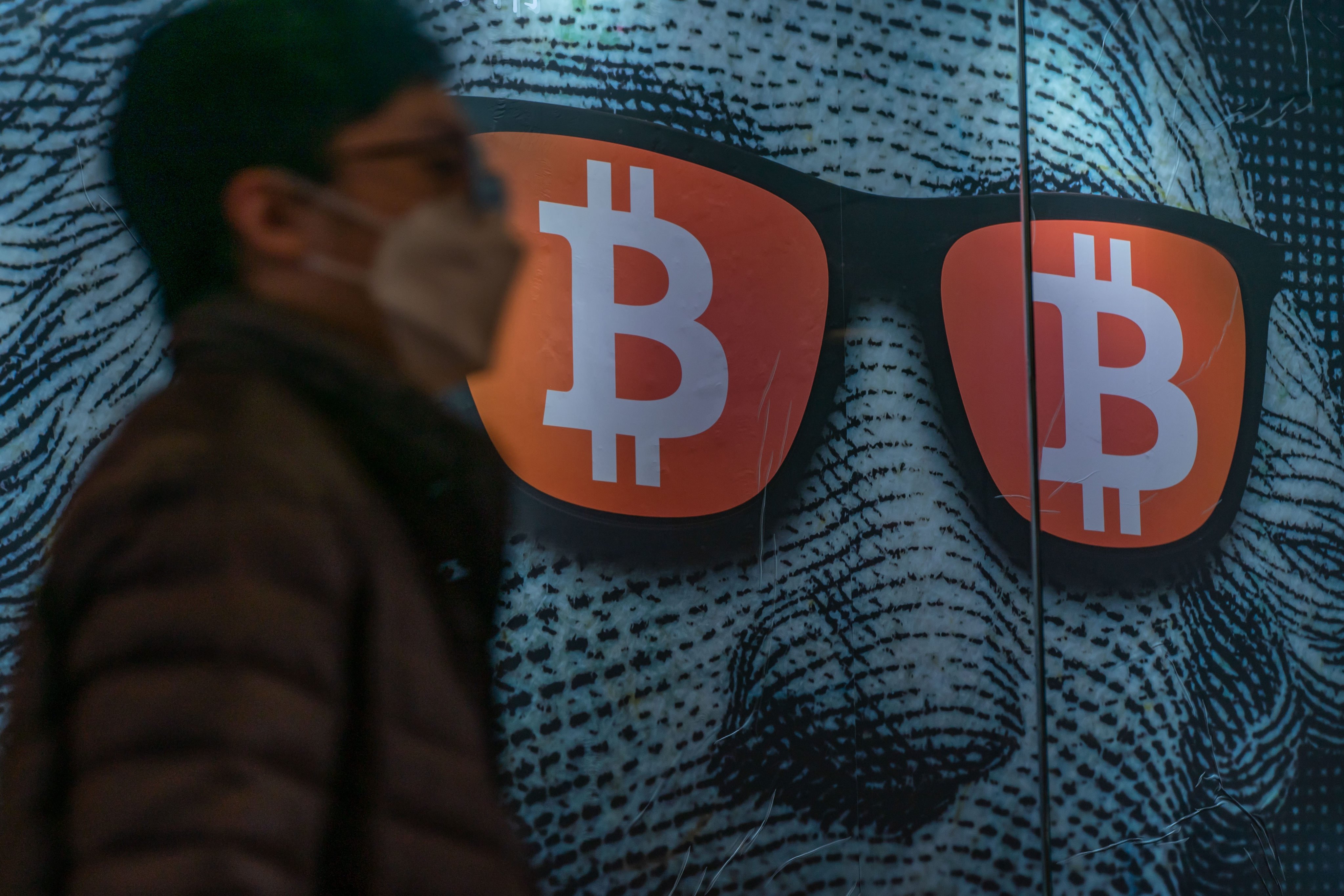 A pedestrian walks past a bitcoin display in Hong Kong, February 15, 2022. Photo: Getty Images