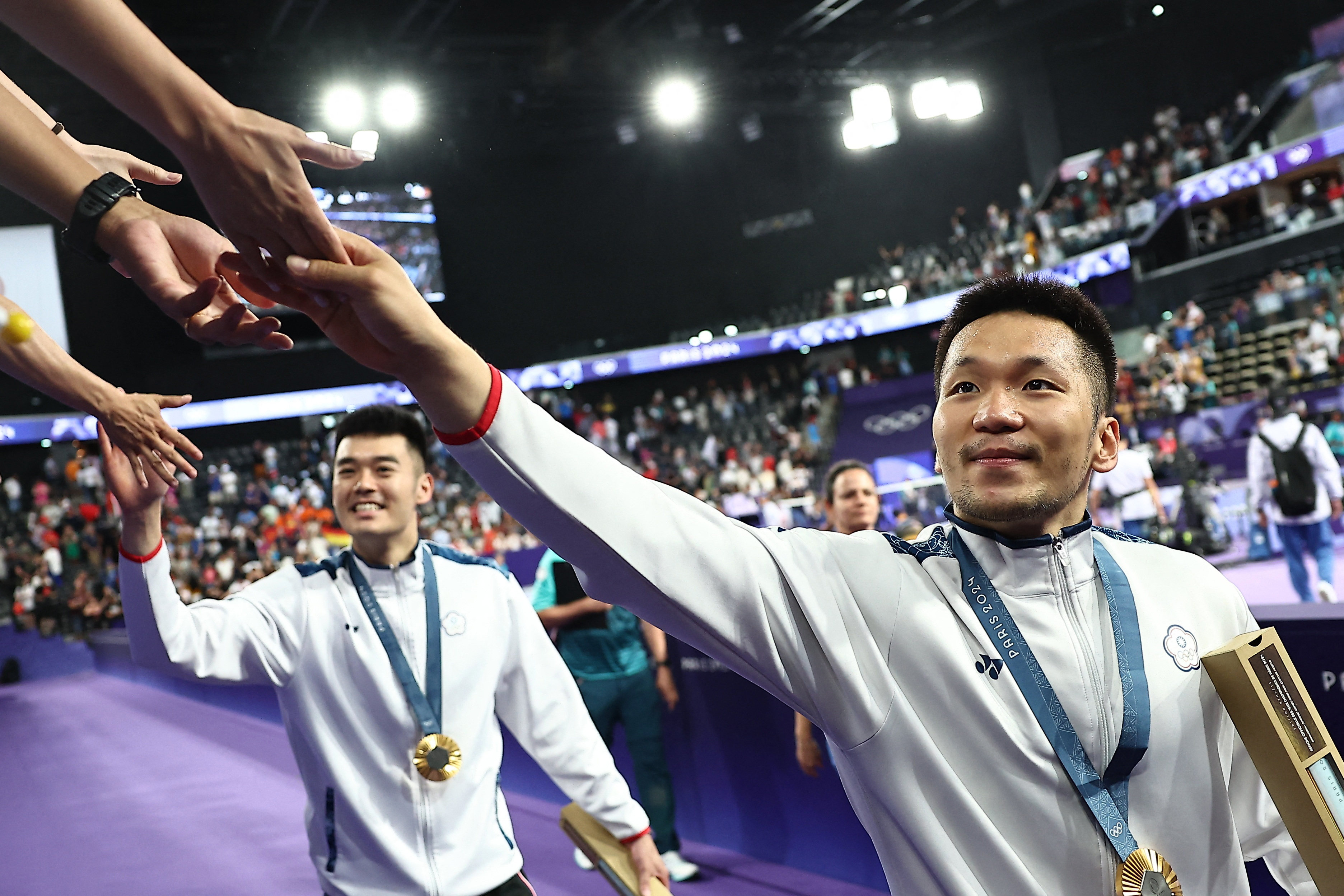 Gold medallists Wang Chi-lin (left) and Lee Yang greet supporters after their victory. Photo: Reuters