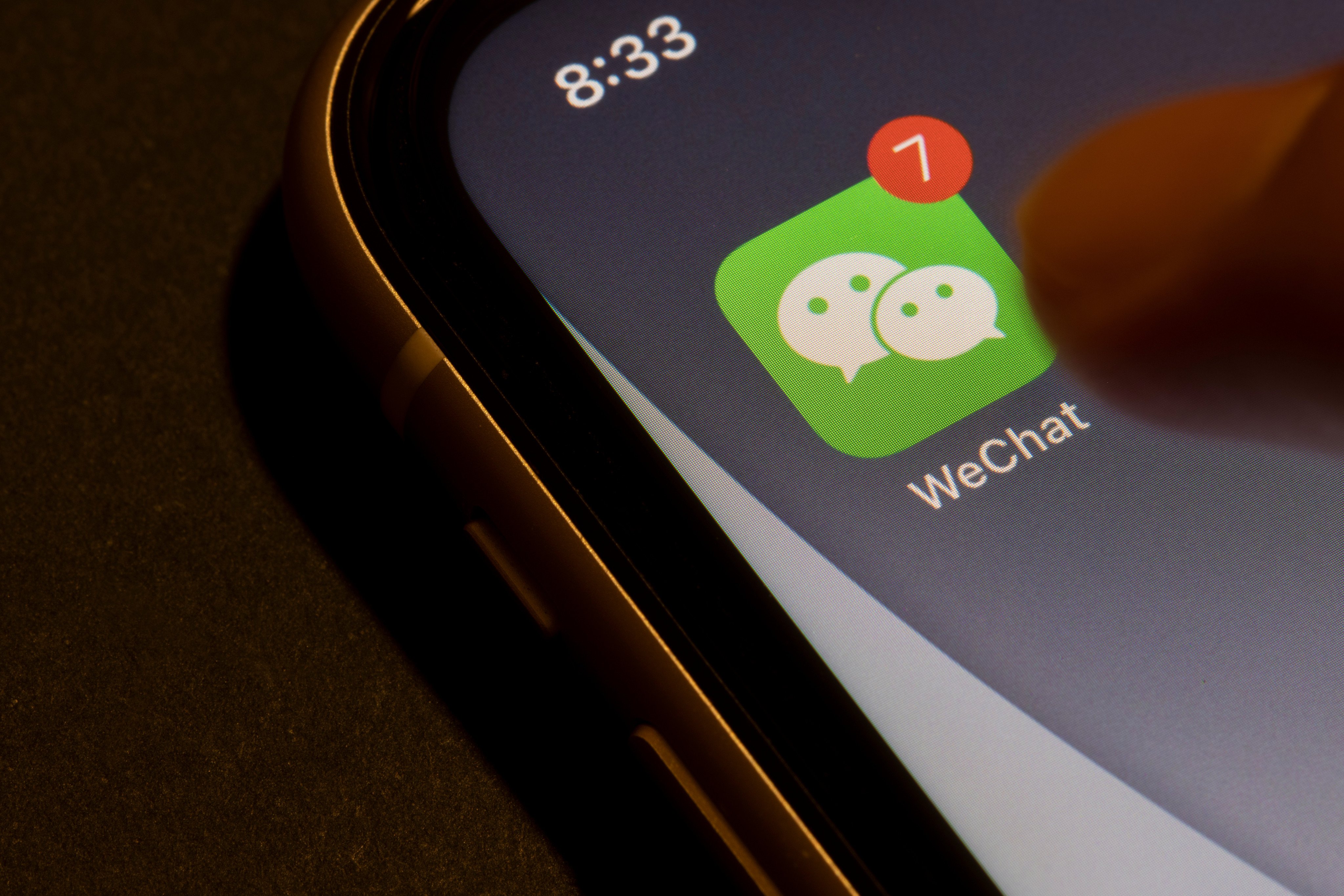 Portland, OR, USA - Aug 19, 2021: Finger touching WeChat app icon with unread message badge on an iPhone. Tencent’s WeChat is a Chinese multi-purpose messaging, social media and mobile payment app. Photo: Shutterstock Images